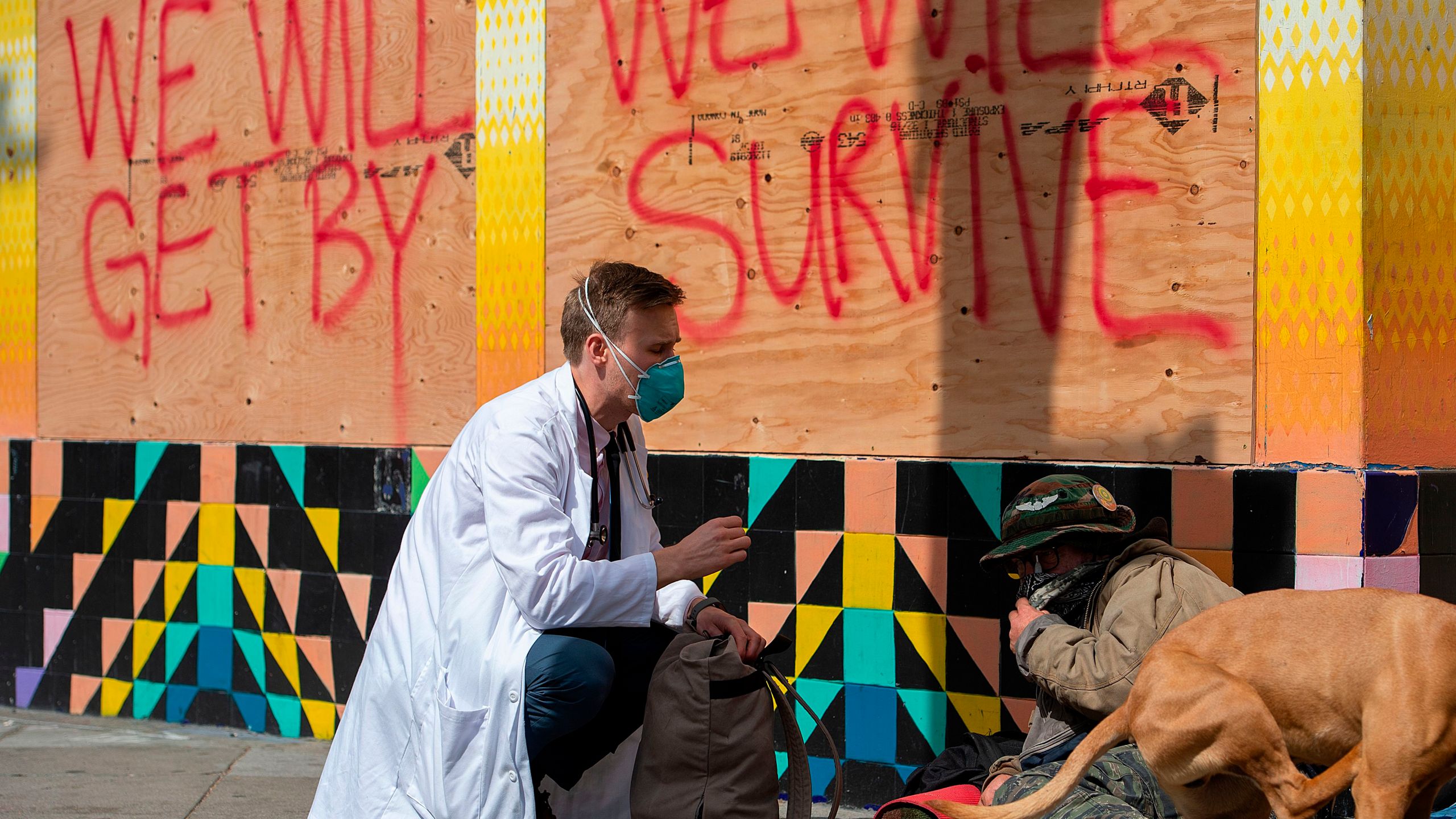 Stuart Malcolm, a doctor with the Haight Ashbury Free Clinic, speaks with homeless people in San Francisco about the coronavirus on March 17, 2020. (Credit: Josh Edelson / AFP / Getty Images)