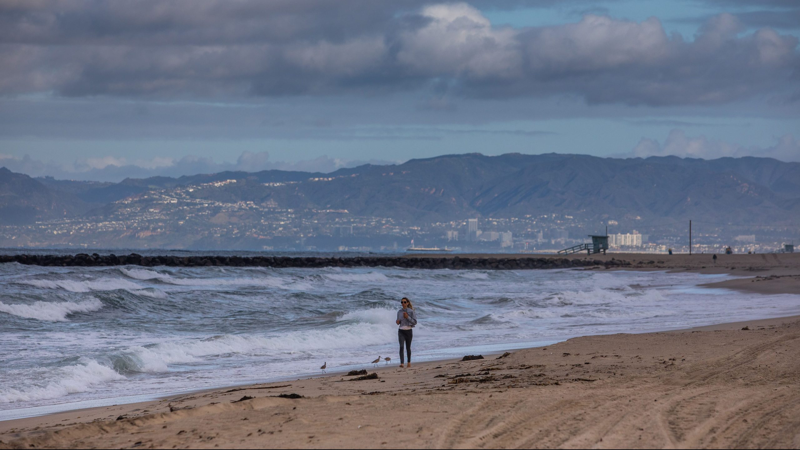 A woman runs in the morning on a deserted beach in El Segundo on March 19, 2020, as the region was gripped the coronavirus crisis. (Apu Gomes / AFP / Getty Images)