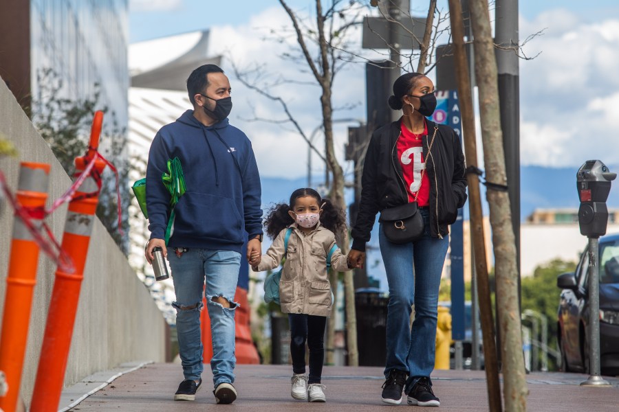 A family walks wearing masks in downtown Los Angeles on March 22, 2020, during the coronavirus outbreak. (APU GOMES/AFP via Getty Images)