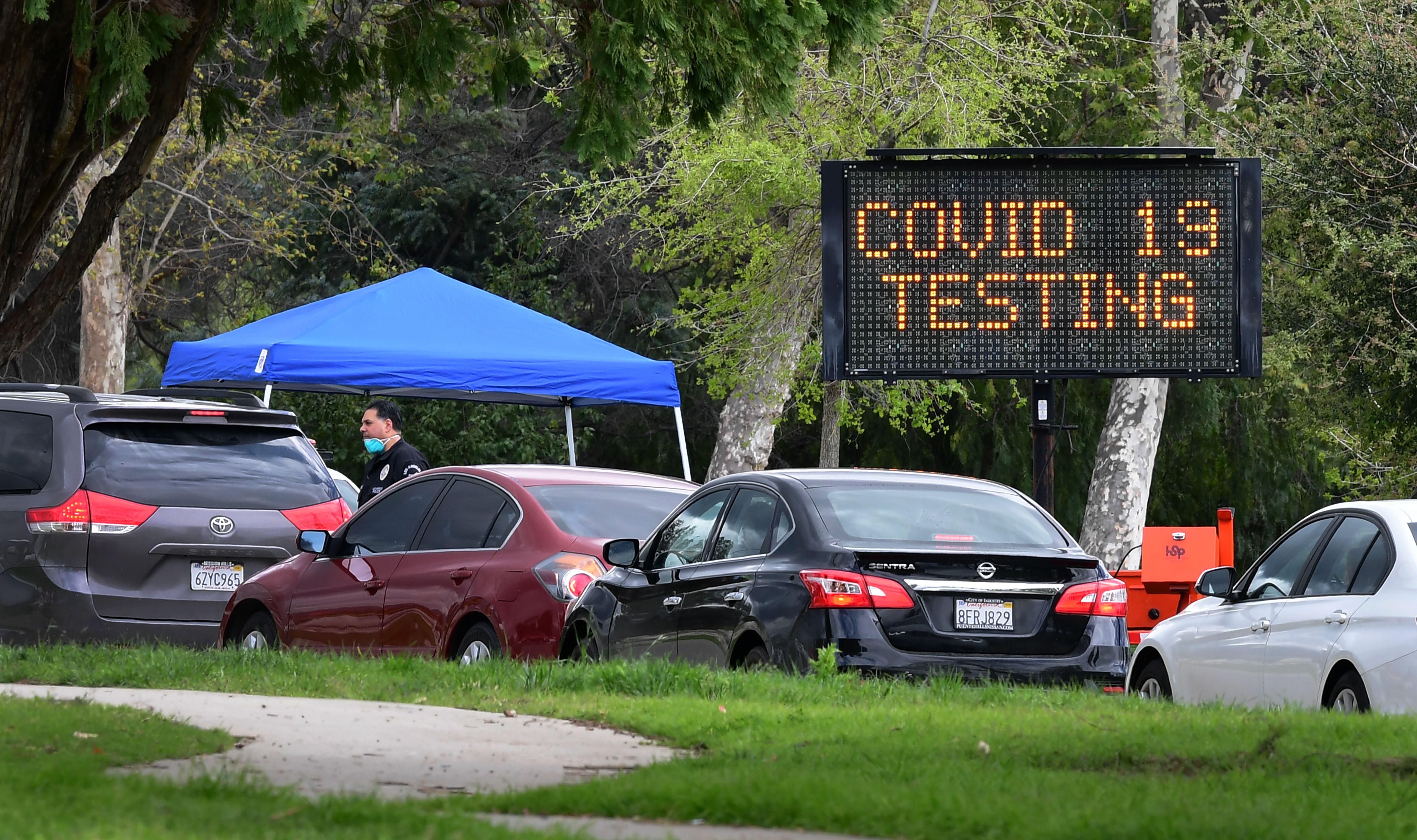 A police officer mans the entrance to a coronavirus testing center in Hansen Dam Park on March 25, 2020, in Pacoima, California. (FREDERIC J. BROWN/AFP via Getty Images)