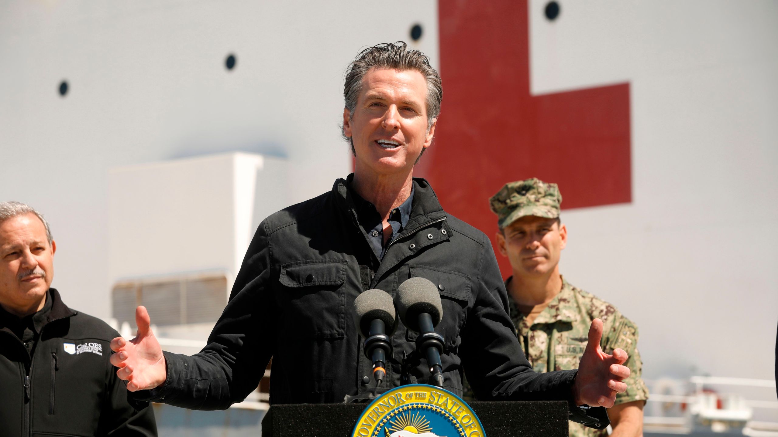 California Gov. Gavin Newsom speaks in front of the hospital ship USNS Mercy after it arrived into the Port of Los Angeles on March 27, 2020. (Carolyn Cole/POOL/AFP via Getty Images)