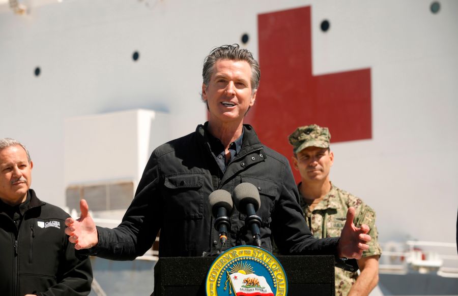 California Gov. Gavin Newsom speaks in front of the hospital ship USNS Mercy after it arrived into the Port of Los Angeles on March 27, 2020. (Carolyn Cole/POOL/AFP via Getty Images)