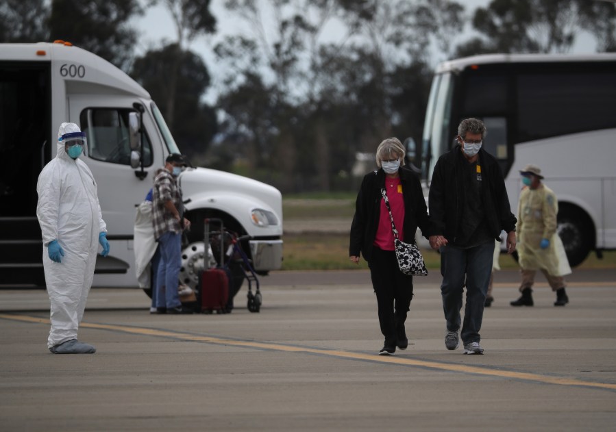 Passengers from the Grand Princess cruise ship walk across the tarmac before boarding a charter plane at Oakland International Airport on March 10, 2020, in Oakland. (Justin Sullivan/Getty Images)