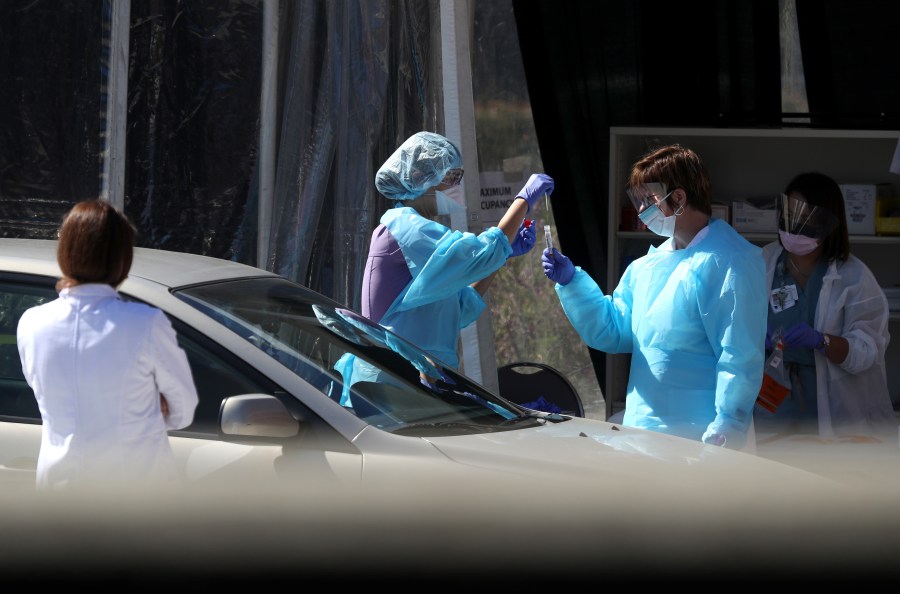 Medical personnel take a sample from a person at a drive-thru coronavirus testing station at a Kaiser Permanente facility on March 12, 2020 in San Francisco. (Justin Sullivan/Getty Images)