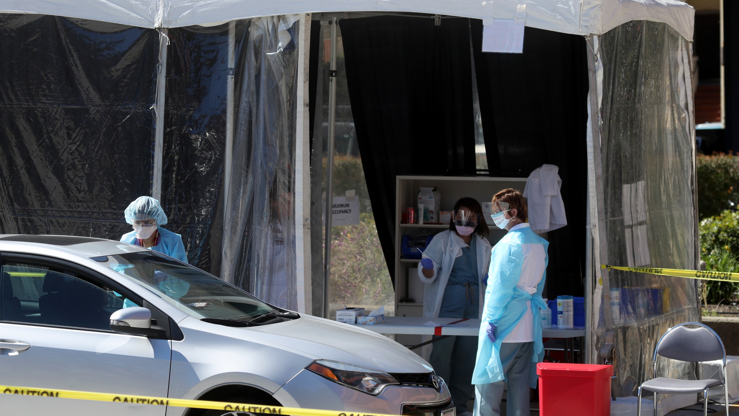 Medical personnel take a sample from a person at a drive-thru coronavirus COVID-19 testing station at a Kaiser Permanente facility on March 12, 2020, in San Francisco, California. (Justin Sullivan/Getty Images)