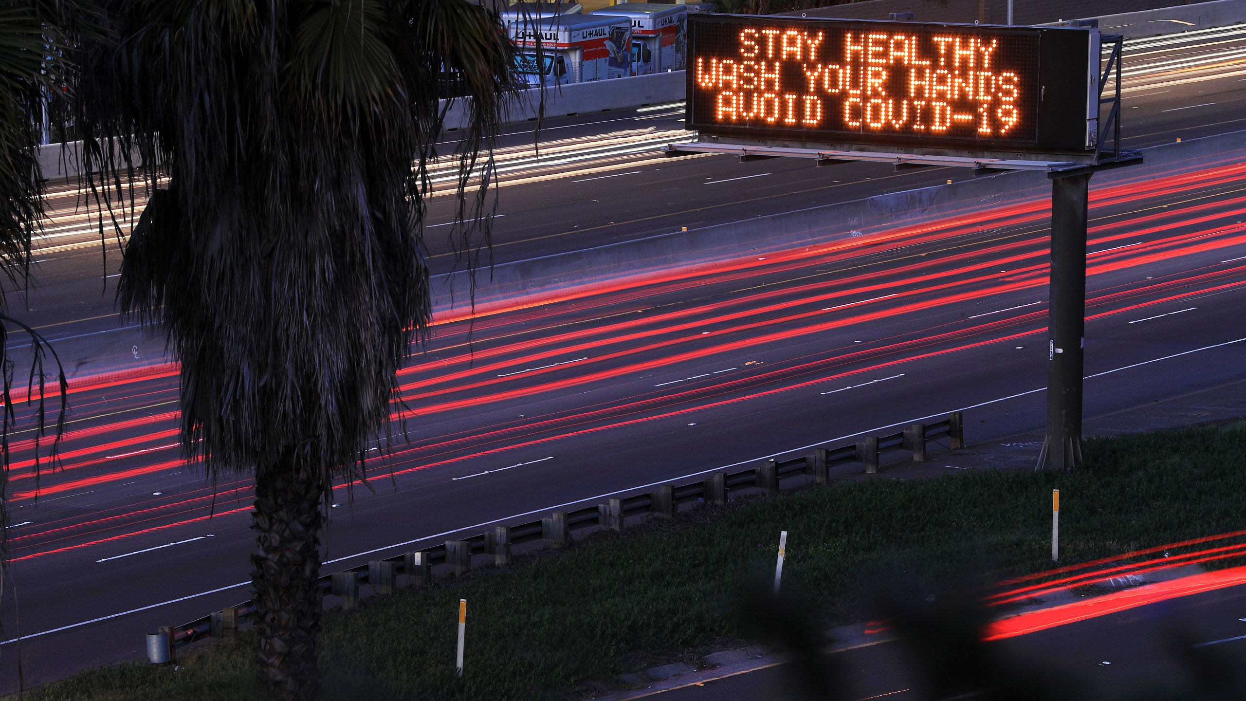 Motorists travel on Interstate 8 in San Diego as a sign encourages hand washing on March 15, 2020. (Credit: Sean M. Haffey / Getty Images)