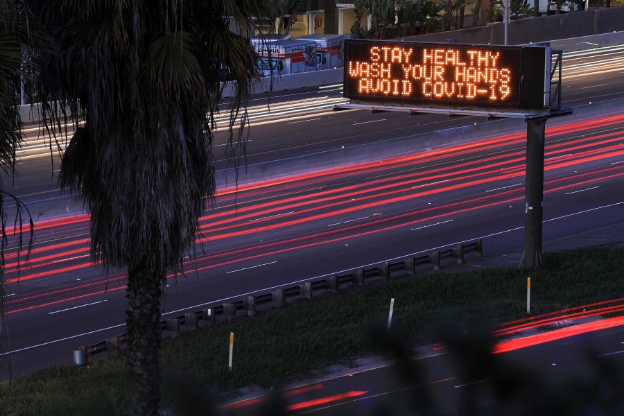 Motorists travel on Interstate 8 in San Diego as a sign encourages hand washing on March 15, 2020. (Credit: Sean M. Haffey / Getty Images)