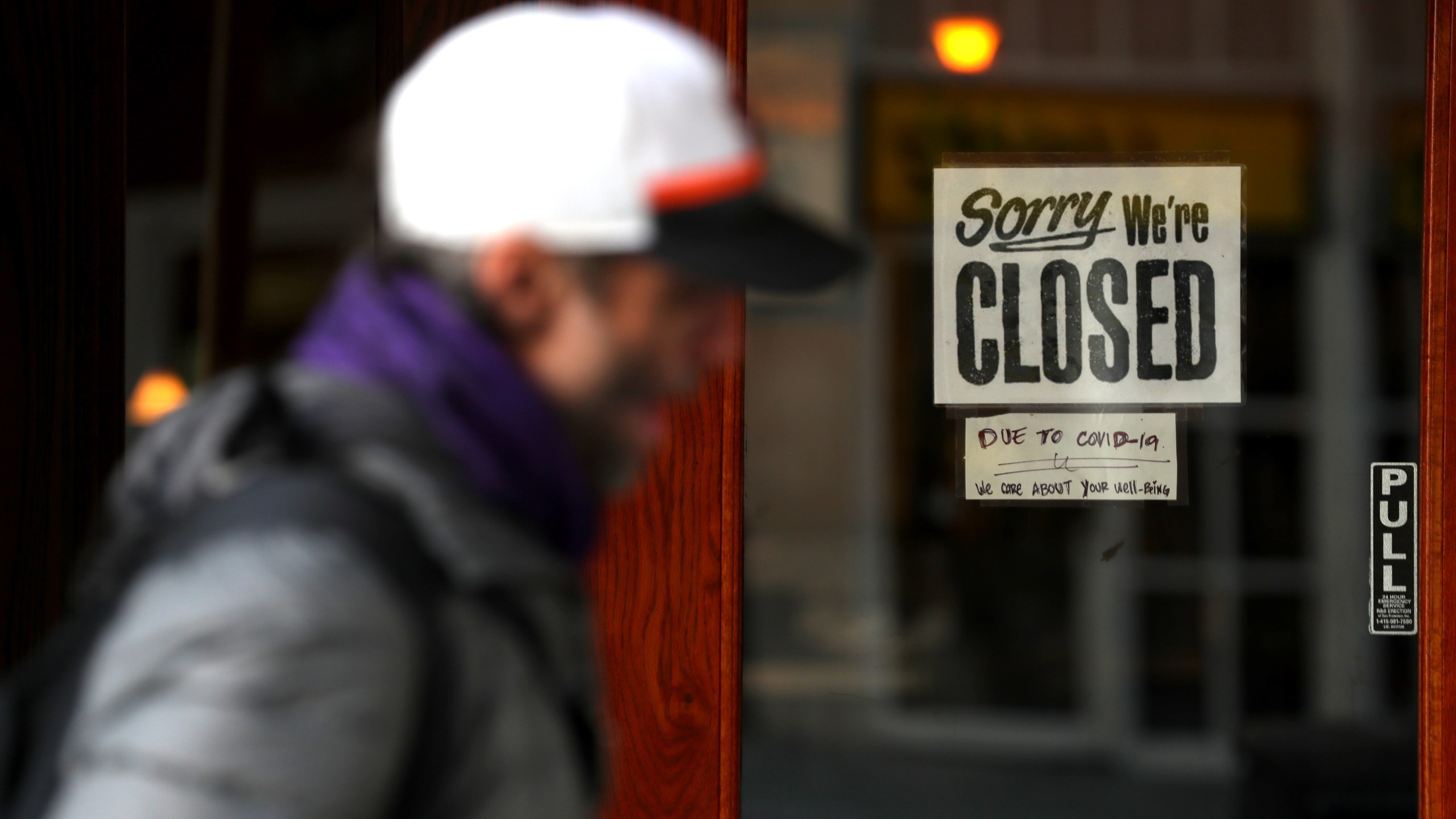 A pedestrian walks by a closed sign on the door of a restaurant in San Francisco on March 17, 2020. (Justin Sullivan / Getty Images)