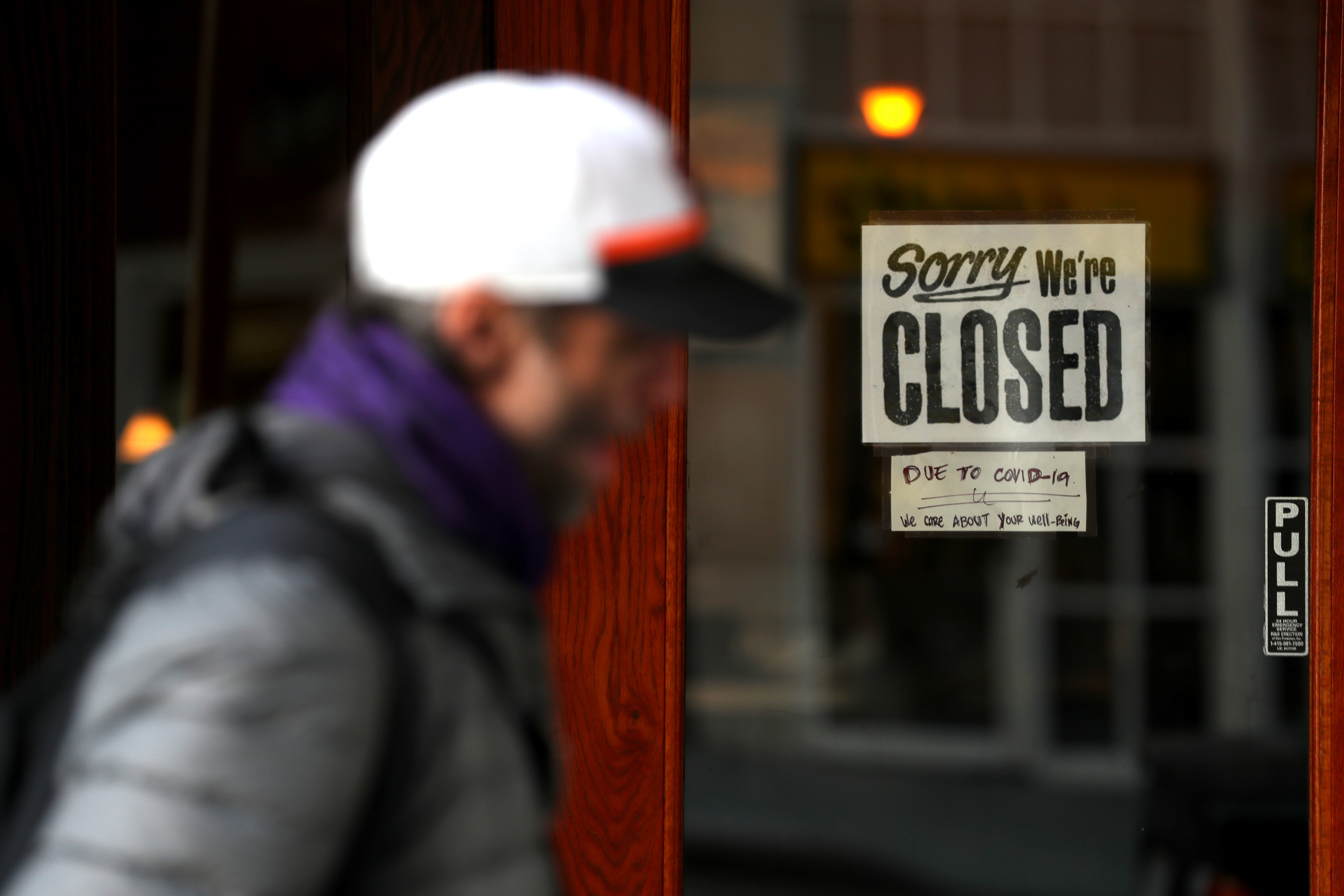 A pedestrian walks by a closed sign on the door of a restaurant in San Francisco on March 17, 2020. (Justin Sullivan / Getty Images)