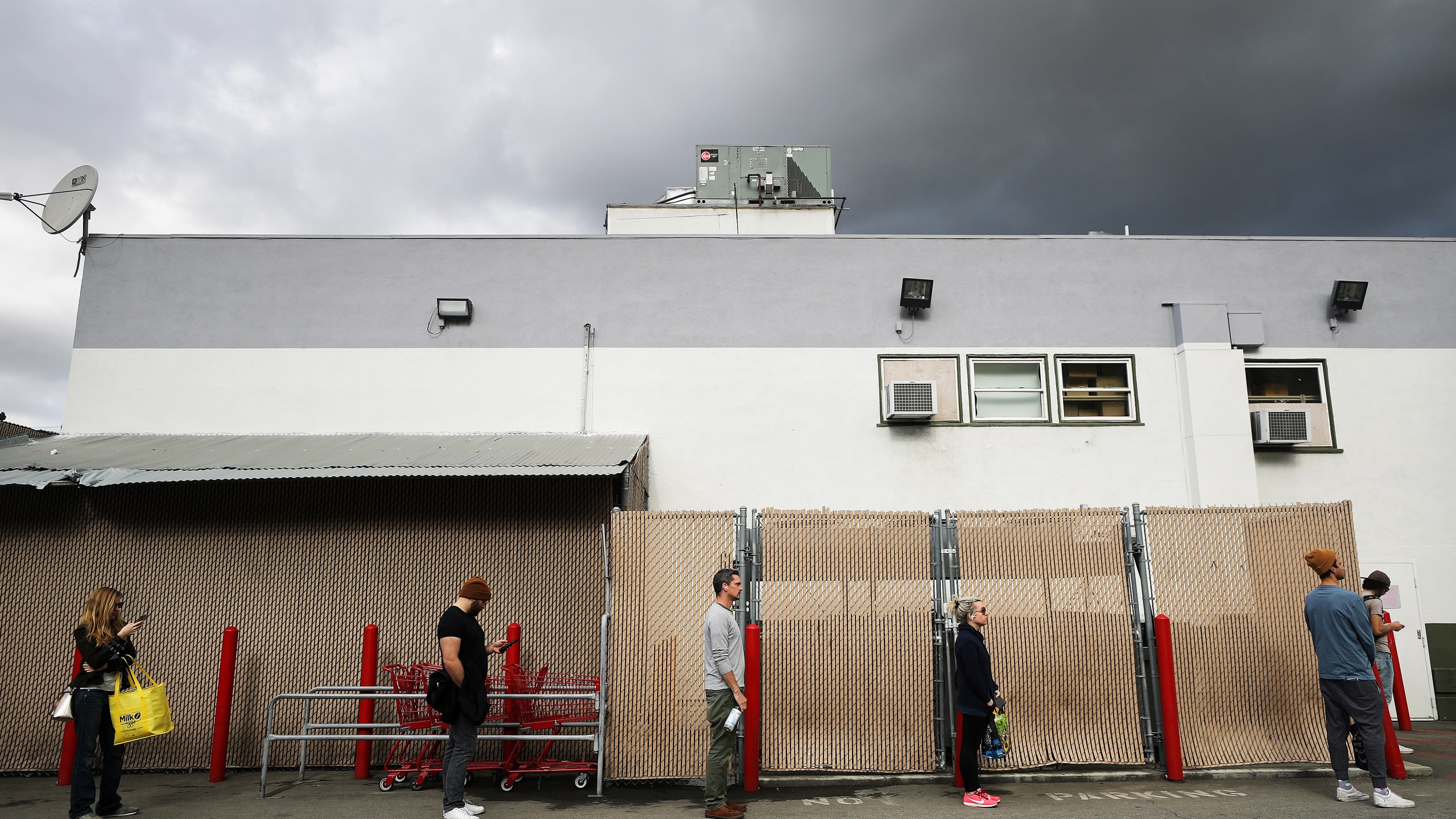 People maintain social distancing while standing in line to enter a Trader Joe's as the coronavirus pandemic continues on March 25, 2020, in Los Angeles. (Mario Tama/Getty Images)