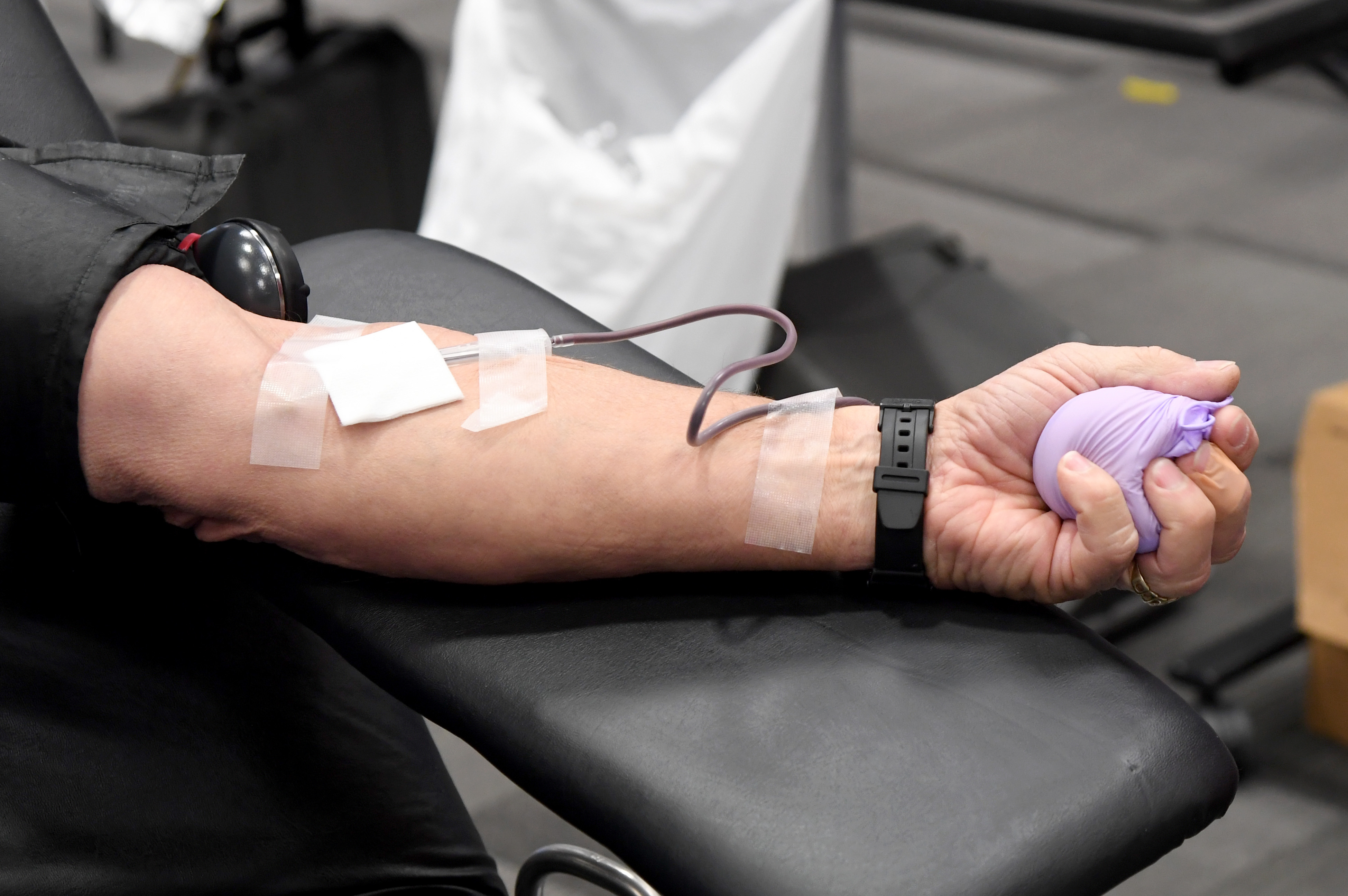 Ken Muller of Nevada squeezes a ball covered in a glove as he donates blood during an American Red Cross blood drive to help alleviate a blood supply shortage as a result of the coronavirus pandemic at Las Vegas Motor Speedway on March 27, 2020 in Las Vegas, Nevada. (Ethan Miller/Getty Images)