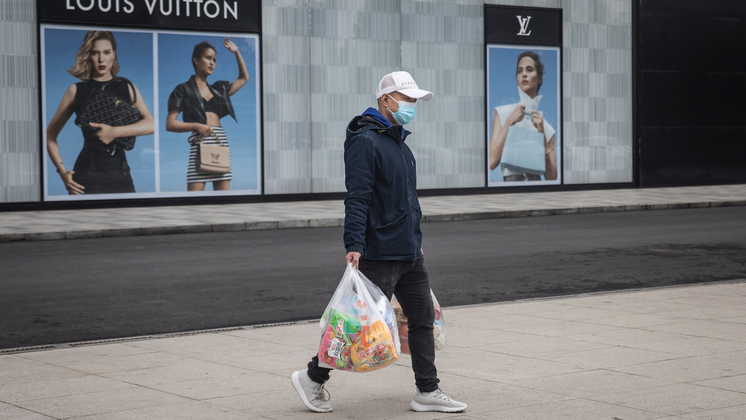 A man wearing a face mask passes a Louis Vuitton store outside Wuhan international plaza on March 30, 2020, in Hubei Province, China. (Getty Images)