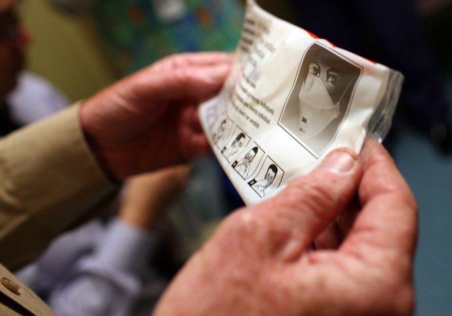 A hospital worker holds up the instructions for using an N95 respiratory mask in a file photo. (Justin Sullivan/Getty Images)