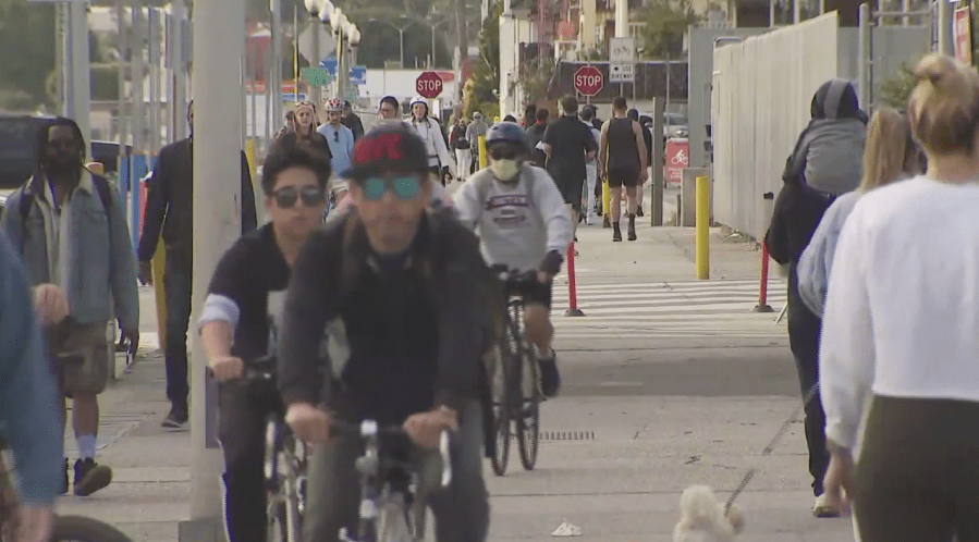 People ride bikes on the Santa Monica Pier on March 22, 2020. (KTLA)