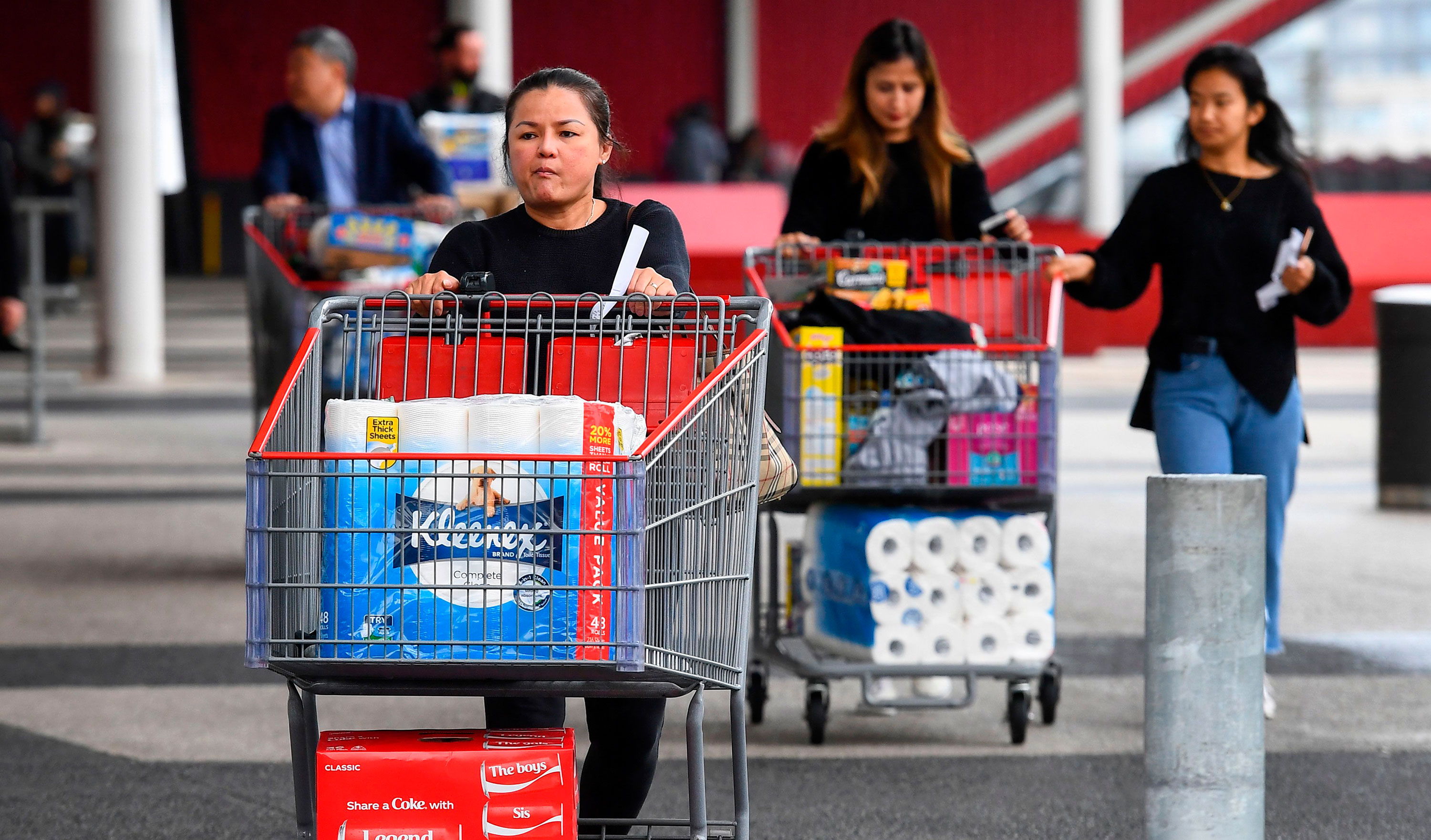 People leave a Costco warehouse with rolls of toilet paper amongst their groceries in Melbourne on March 5, 2020. (William West/AFP/Getty Images via CNN Wire)