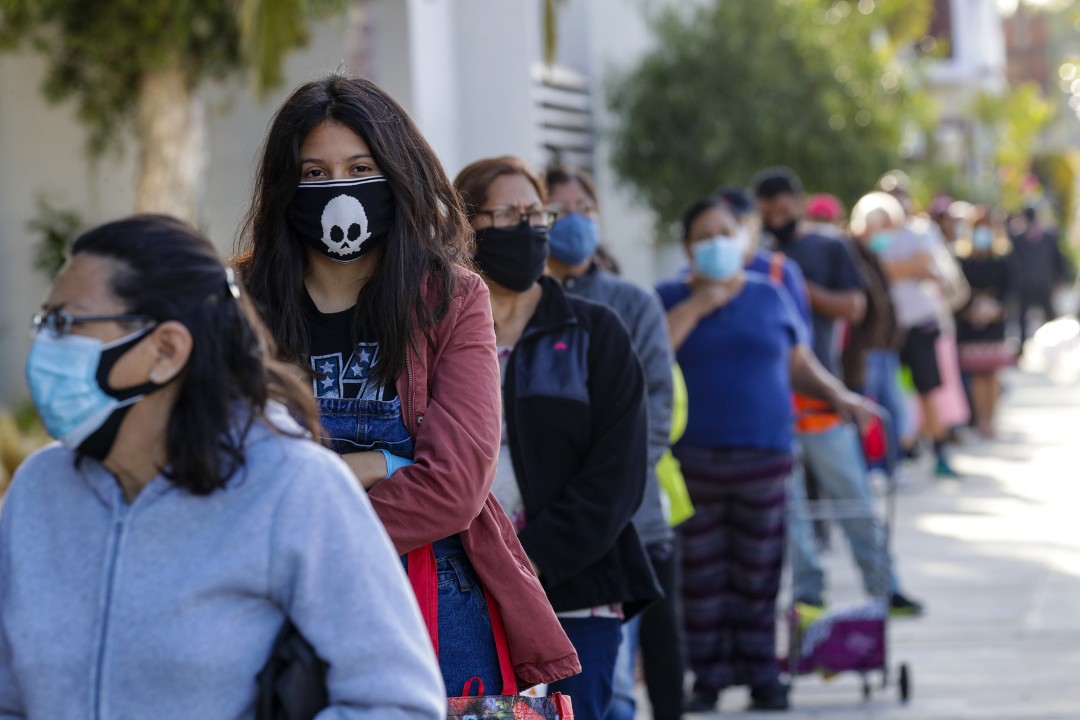 People wait for food bags at James A. Garfield High School in Los Angeles amid the coronavirus pandemic. (Irfan Khan / Los Angeles Times)