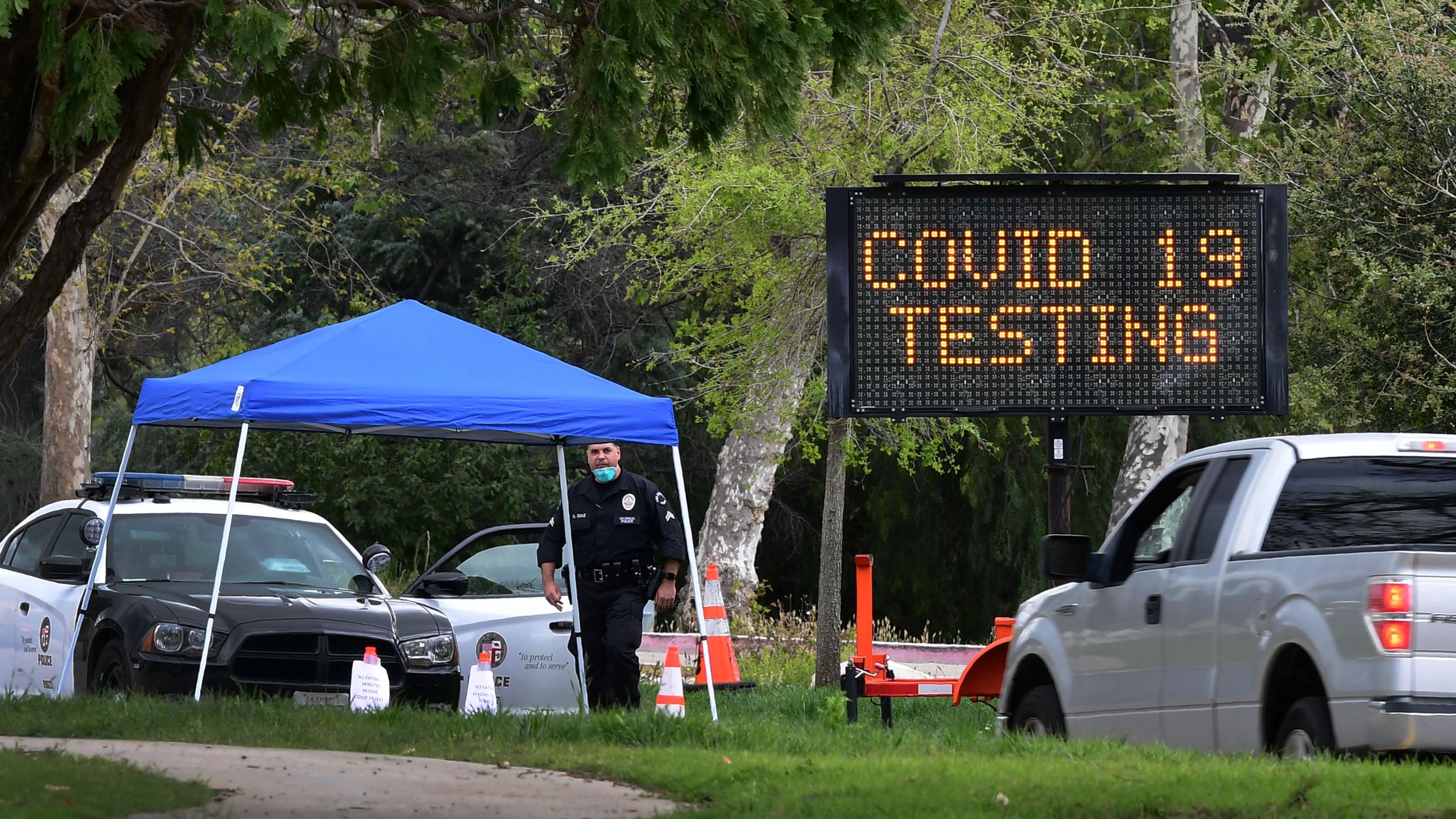 A police officer mans the entrance to a coronavirus (COVID-19) testing center in Hansen Dam Park on March 25, 2020 in Pacoima. (FREDERIC J. BROWN/AFP via Getty Images)