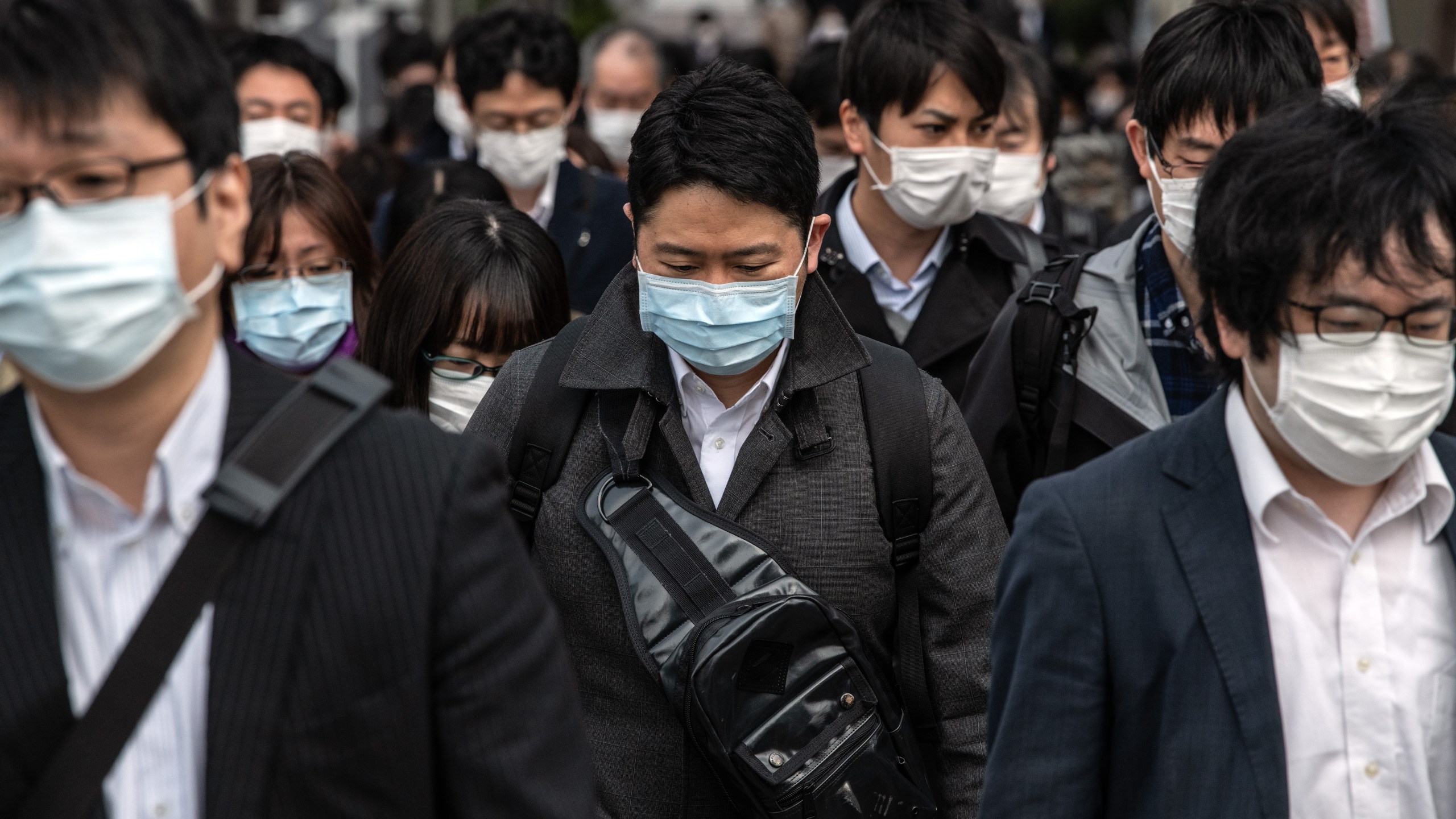 Commuters wearing face masks walk to work the day before a state of emergency is expected to be imposed on April 7, 2020, in Tokyo, Japan. (Carl Court/Getty Images)