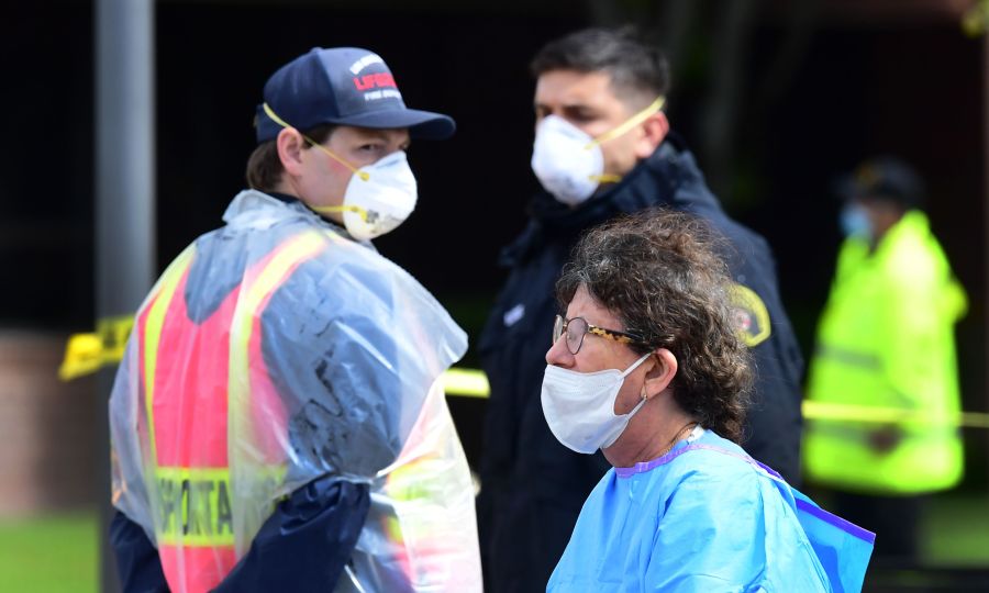 Medical and security personnel wear facemasks amid the coronavirus pandemic on the first day of COVID-19 testing at the Charles R. Drew University of Medicine in south Los Angeles on April 8, 2020. (FREDERIC J. BROWN/AFP via Getty Images)