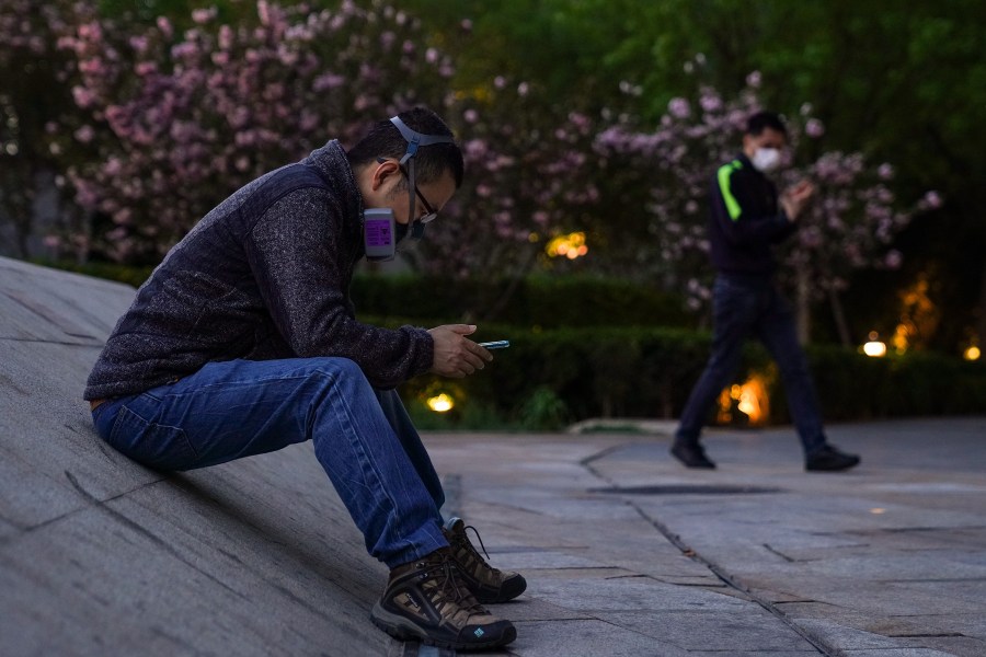 A Chinese man wears a protective mask as they he sit outside a shopping mall on April 12, 2020, in Beijing, China. (Lintao Zhang/Getty Images)