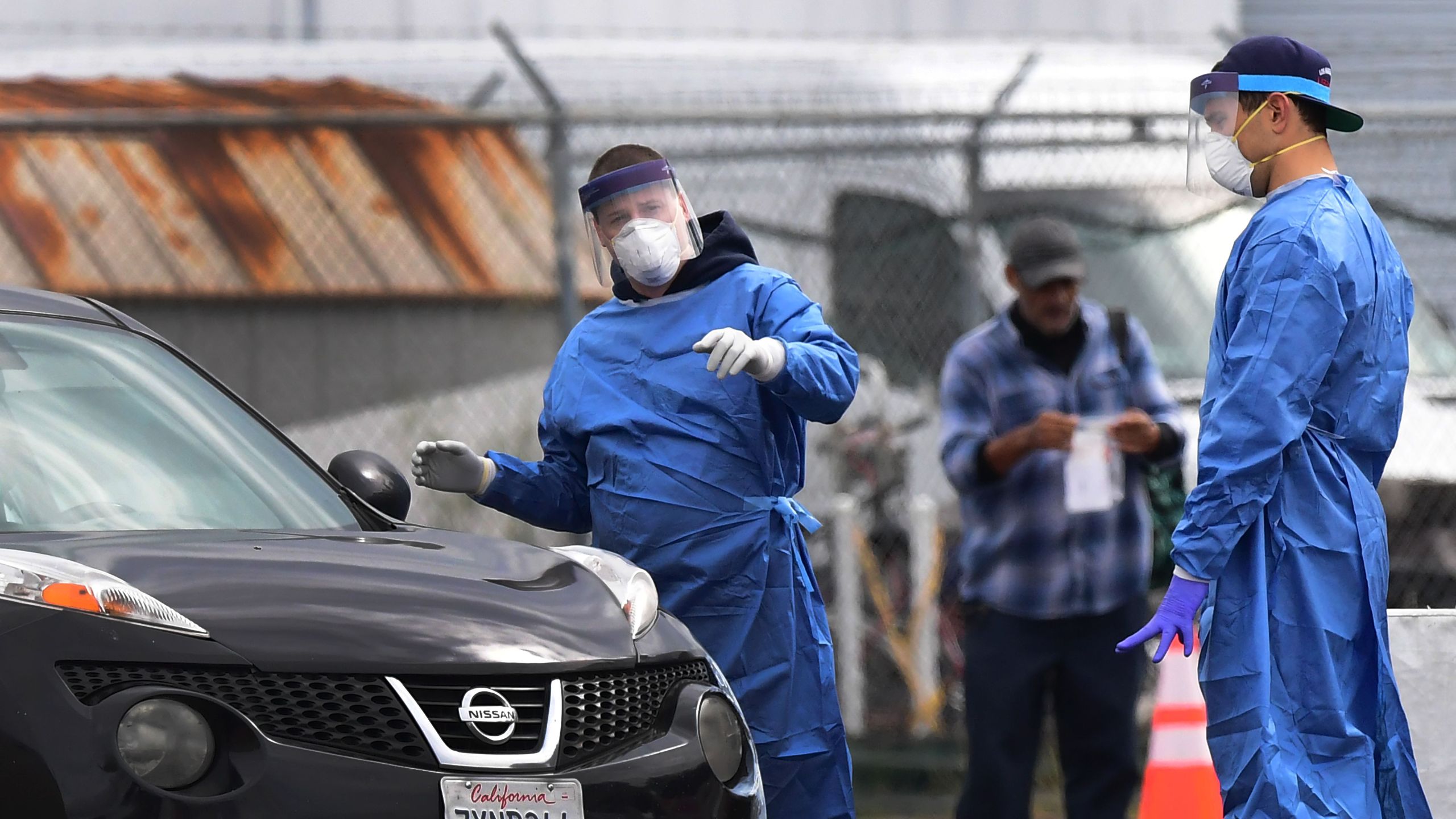 Health care workers offer directions after giving a coronavirus test kit to a driver at the appointment-only San Gabriel Valley Airport testing site in El Monte on April 17, 2020. (FREDERIC J. BROWN/AFP via Getty Images)