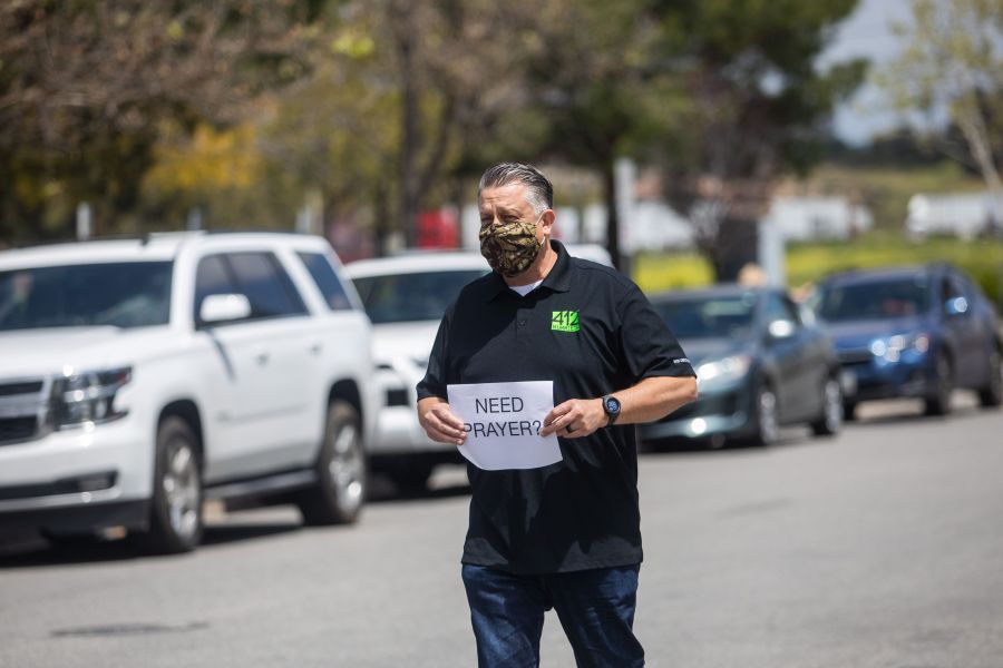 Simon Cooper offers prayers to people who attended an on line Sunday Service inside their cars at the Christian '412 Church Murrieta' parking lot on April 19, 2020. (Apu GOMES / AFP via Getty Images)