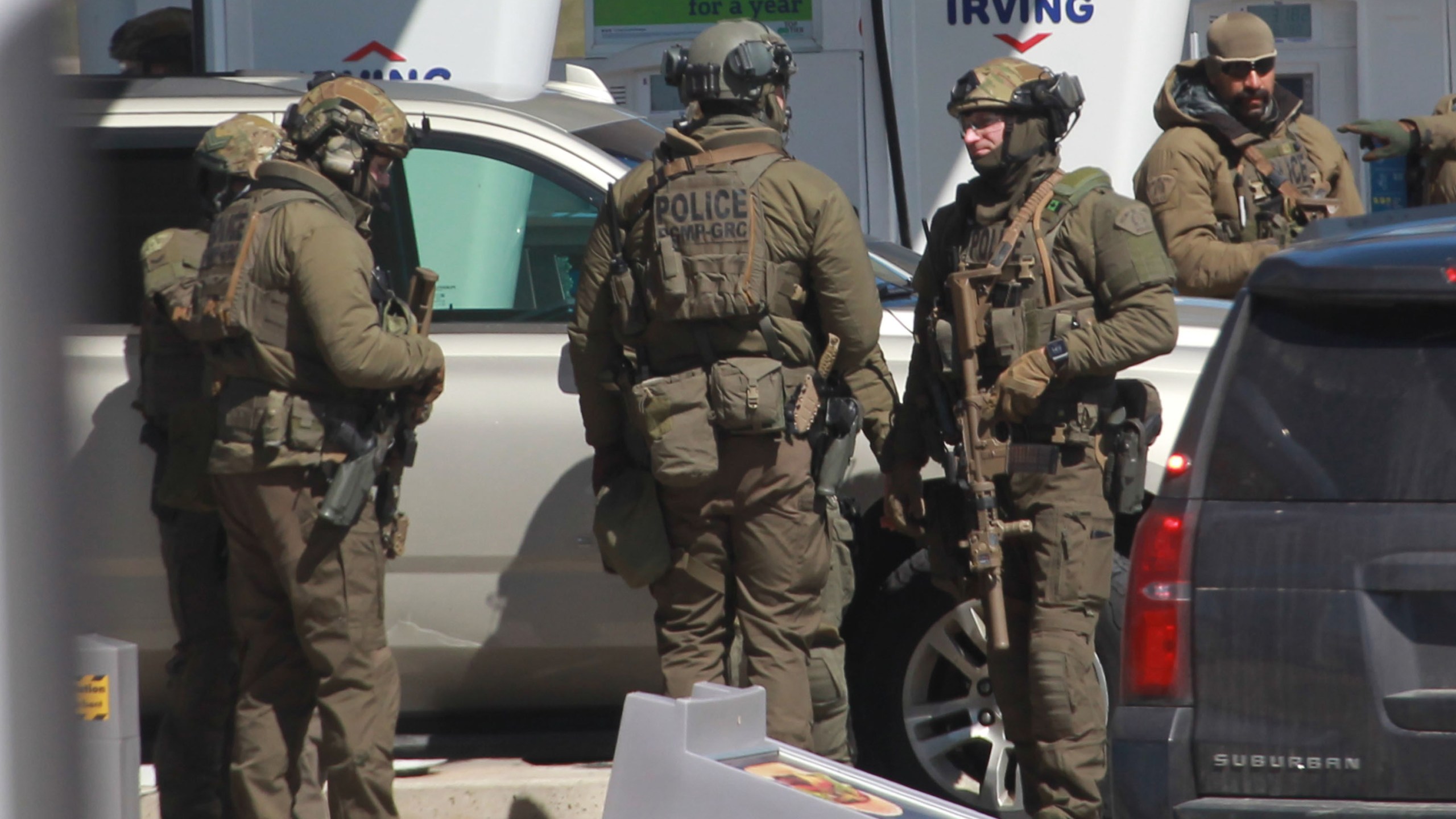 Members of the Royal Canadian Mounted Police tactical unit confer after the suspect in a deadly shooting rampage was killed at the Big Stop near Elmsdale, Nova Scotia, Canada, on April 19, 2020. (TIM KROCHAK/AFP via Getty Images)