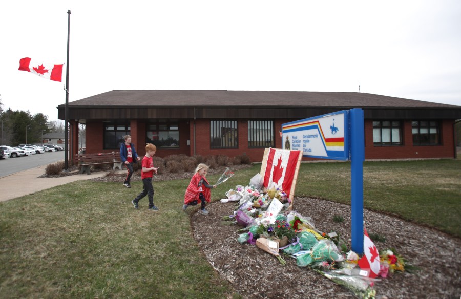 Children lay flowers at an impromptu memorial in front of the RCMP detachment April 20, 2020, in Enfield, Nova Scotia, Canada. It was the home detachment of slain RCMP Constable Heidi Stevenson, who was one of 19 people killed during a shooting rampage in April 2020. (Tim Krochak/Getty Images)