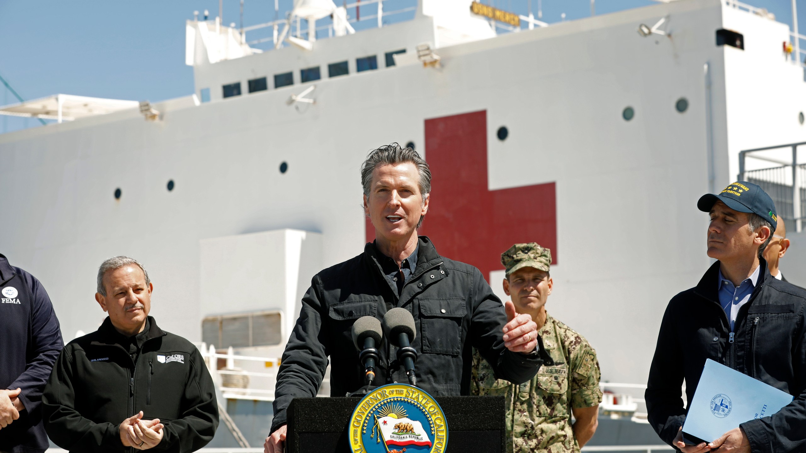 Gov. Gavin Newsom speaks in front of the hospital ship USNS Mercy after it arrived into the Port of Los Angeles on March 27, 2020. (Credit: Carolyn Cole / Getty Images)