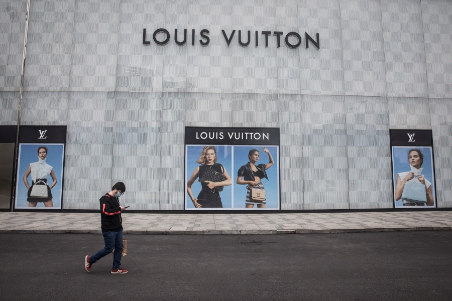 A man wearing a face mask passes a Louis Vuitton store outside Wuhan international plaza on March 30, 2020, in Hubei Province, China. (Getty Images)