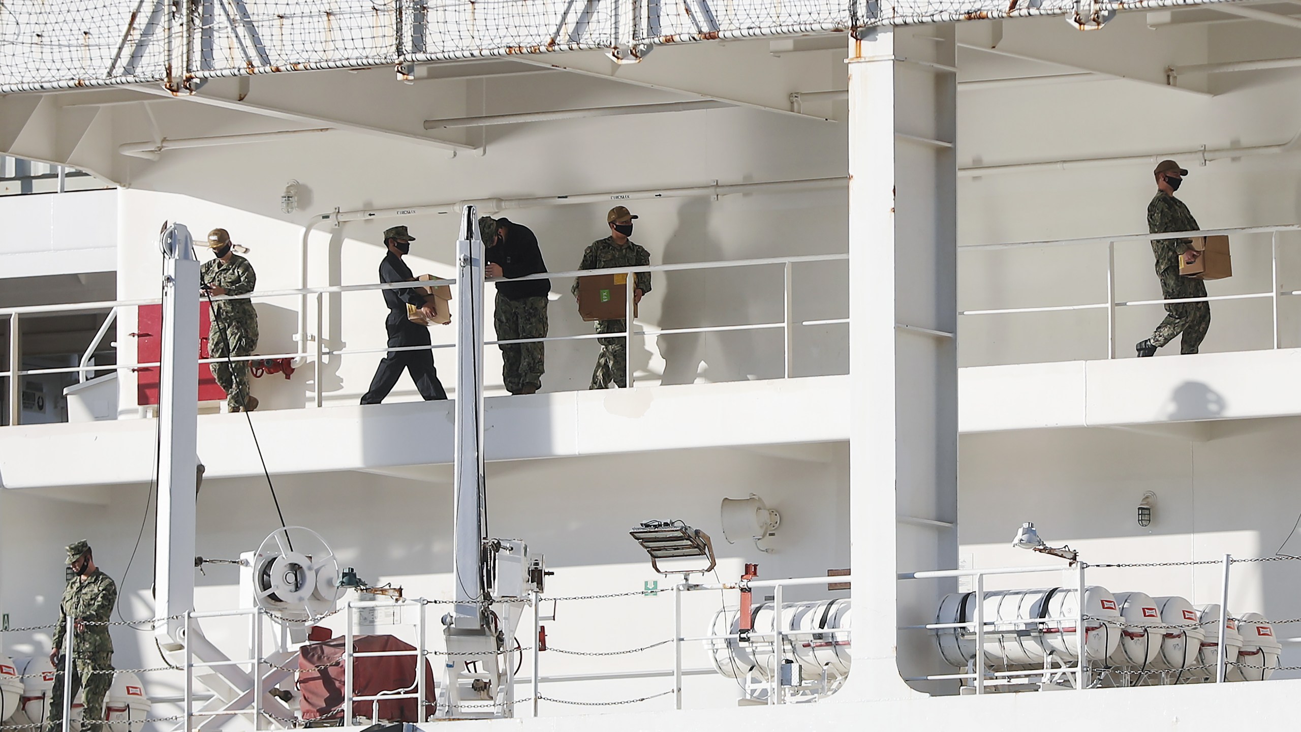 Military personnel wearing face masks work aboard the USNS Mercy hospital ship docked in the Port of Los Angeles amidst the coronavirus pandemic on April 15, 2020. (Credit: Mario Tama / Getty Images)