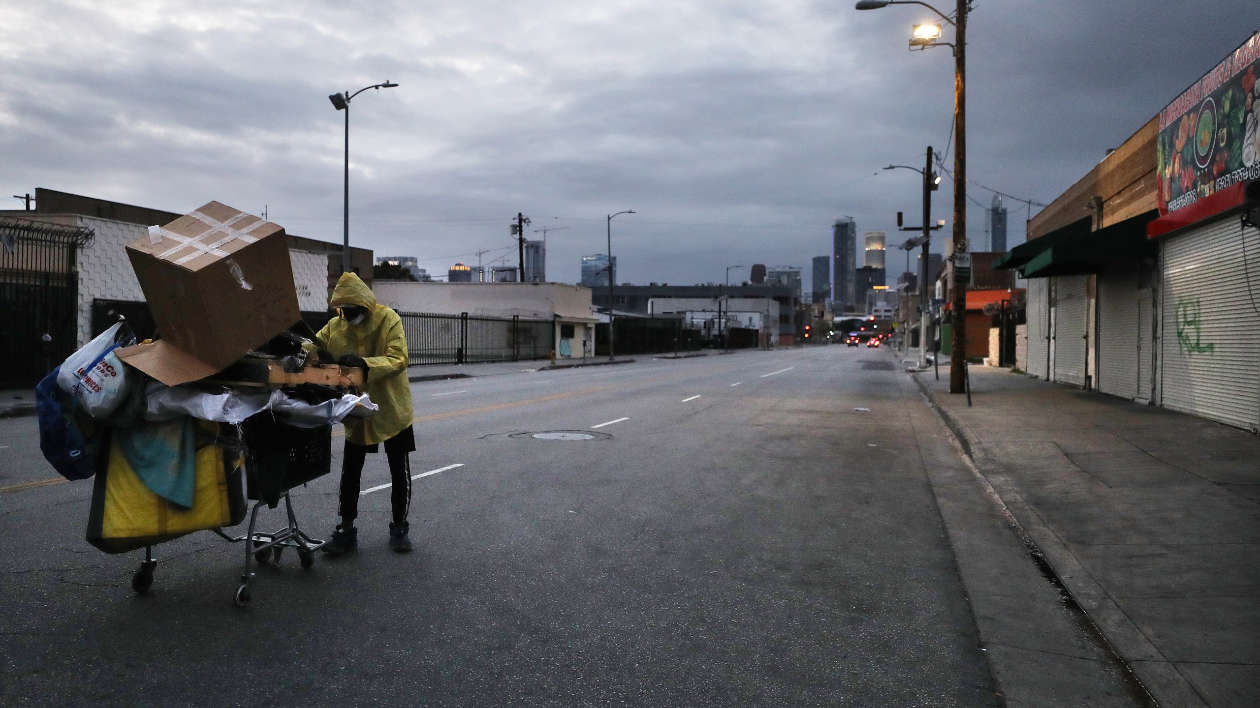 A man who is originally from Texas and currently homeless pushes a cart with his belongings on a downtown Los Angeles street amidst the coronavirus pandemic on April 18, 2020. (Credit: Mario Tama / Getty Images)