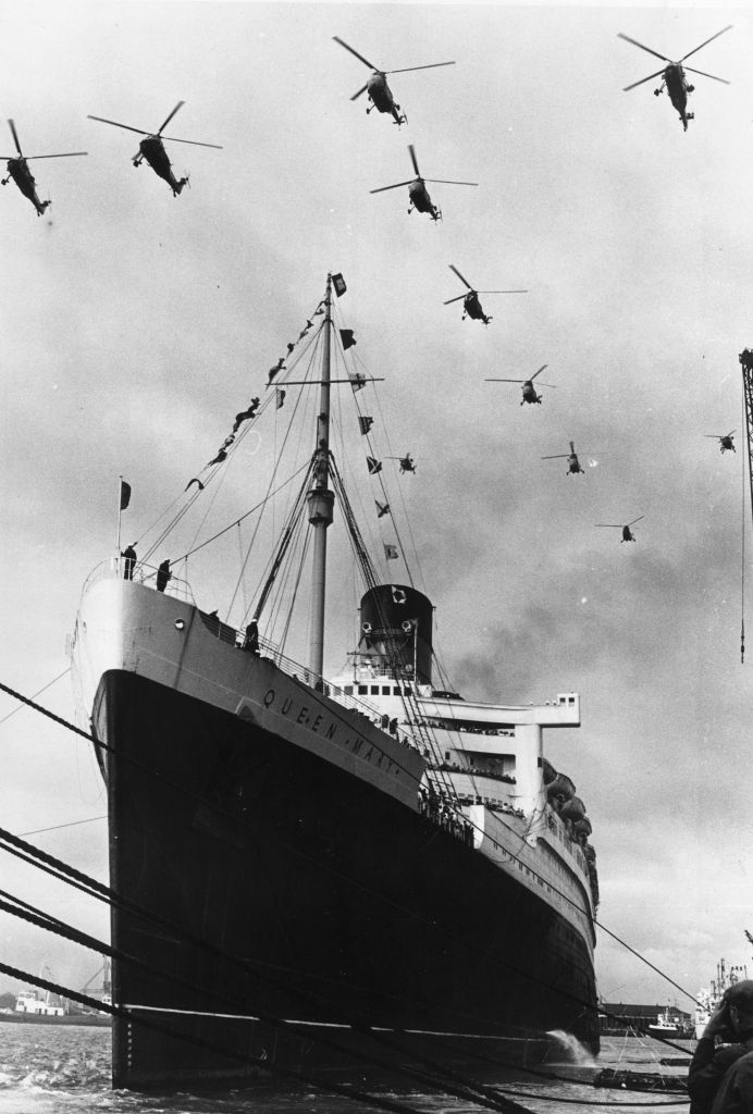 Royal Navy helicopters form the shape of an anchor over the Cunard superliner Queen Mary as she leaves Southampton on her final voyage to Long Beach, California.  (Central Press/Getty Images)