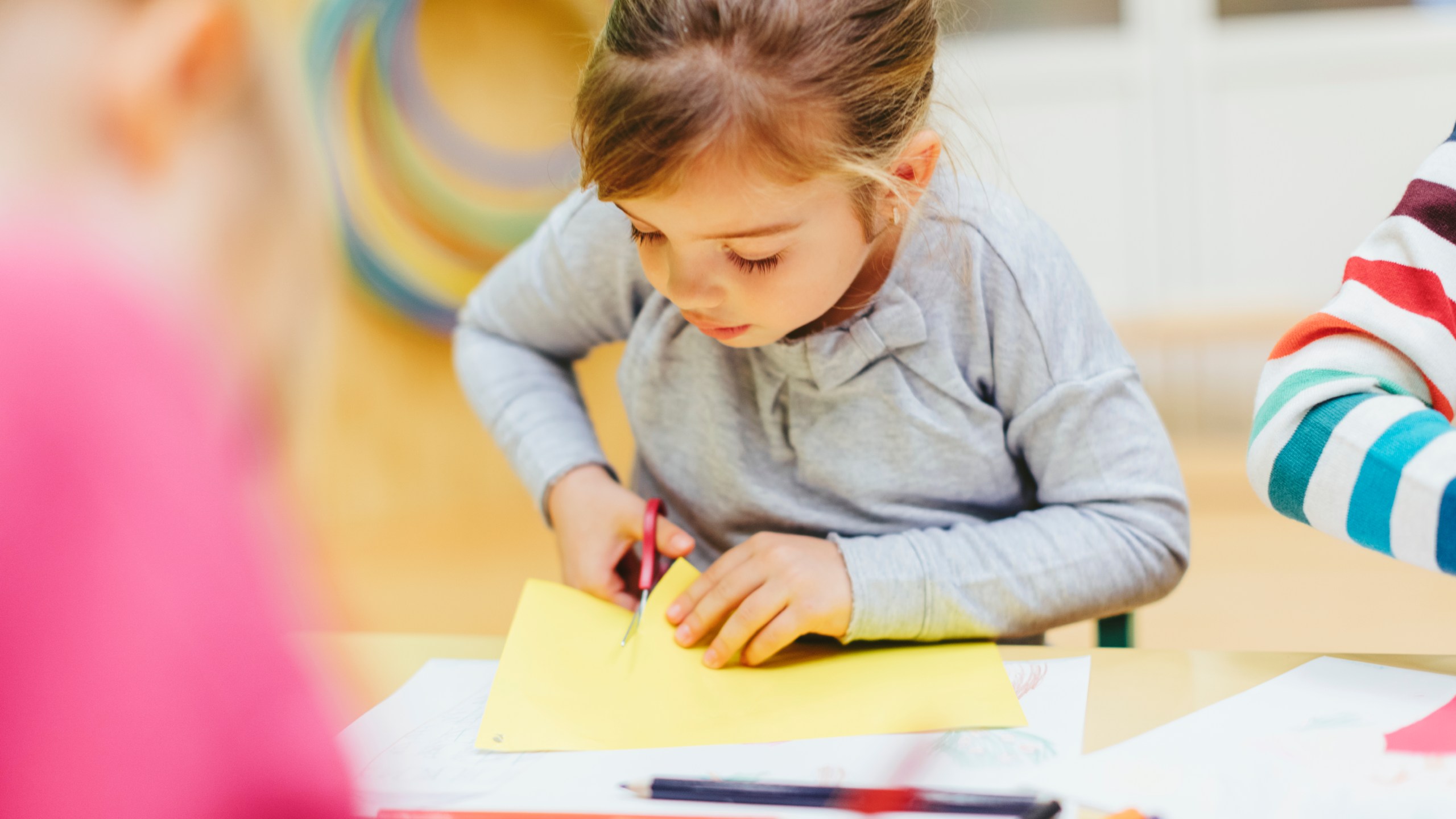 A preschooler cuts colored paper with scissors in this file photo. (Getty Images)