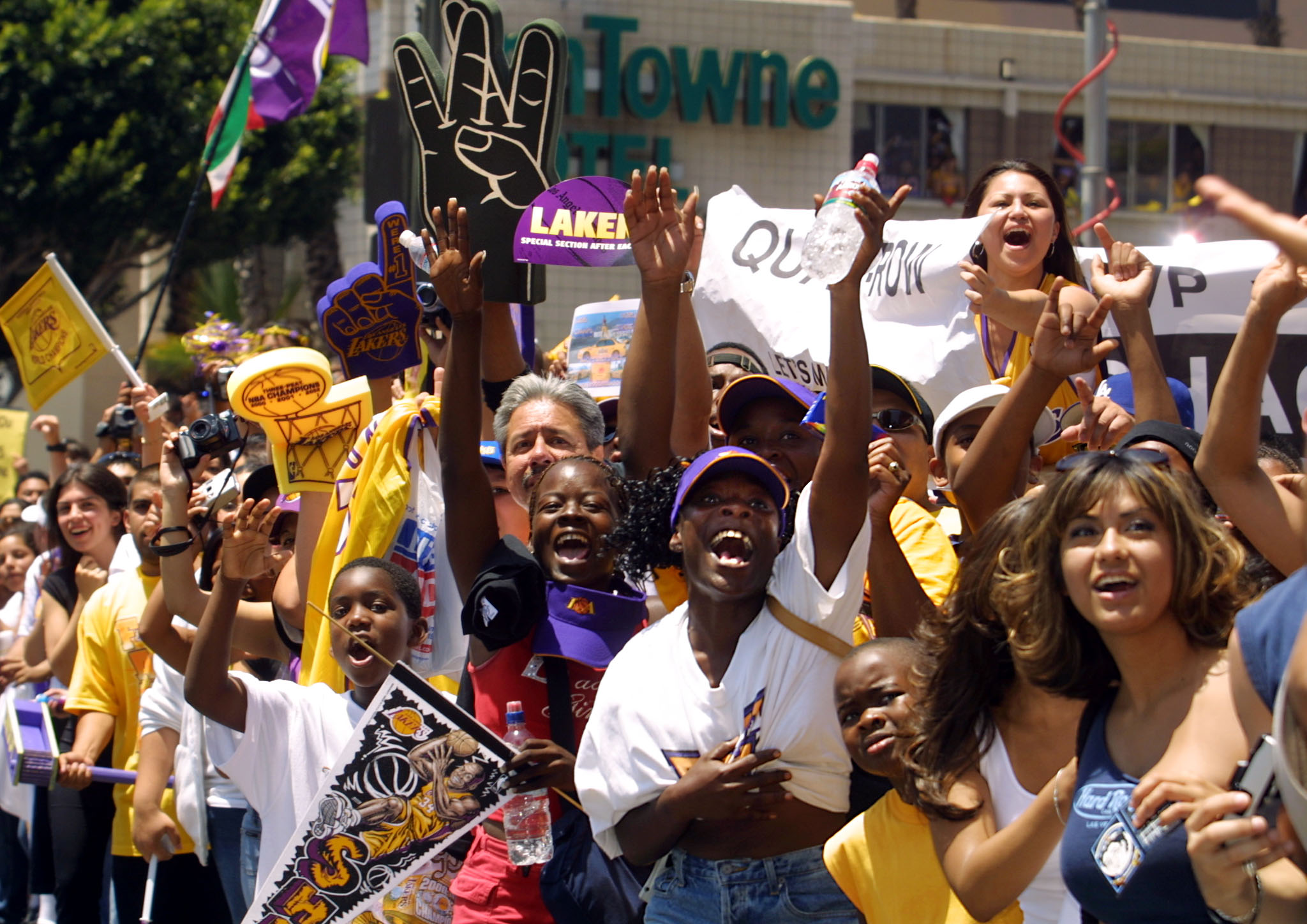 Los Angeles Lakers fans cheer as a float with team members aboard approaches during a parade through downtown Los Angeles, CA celebrating the team's third consecutive NBA championship 14 June, 2002. (LEE CELANO/AFP via Getty Images)