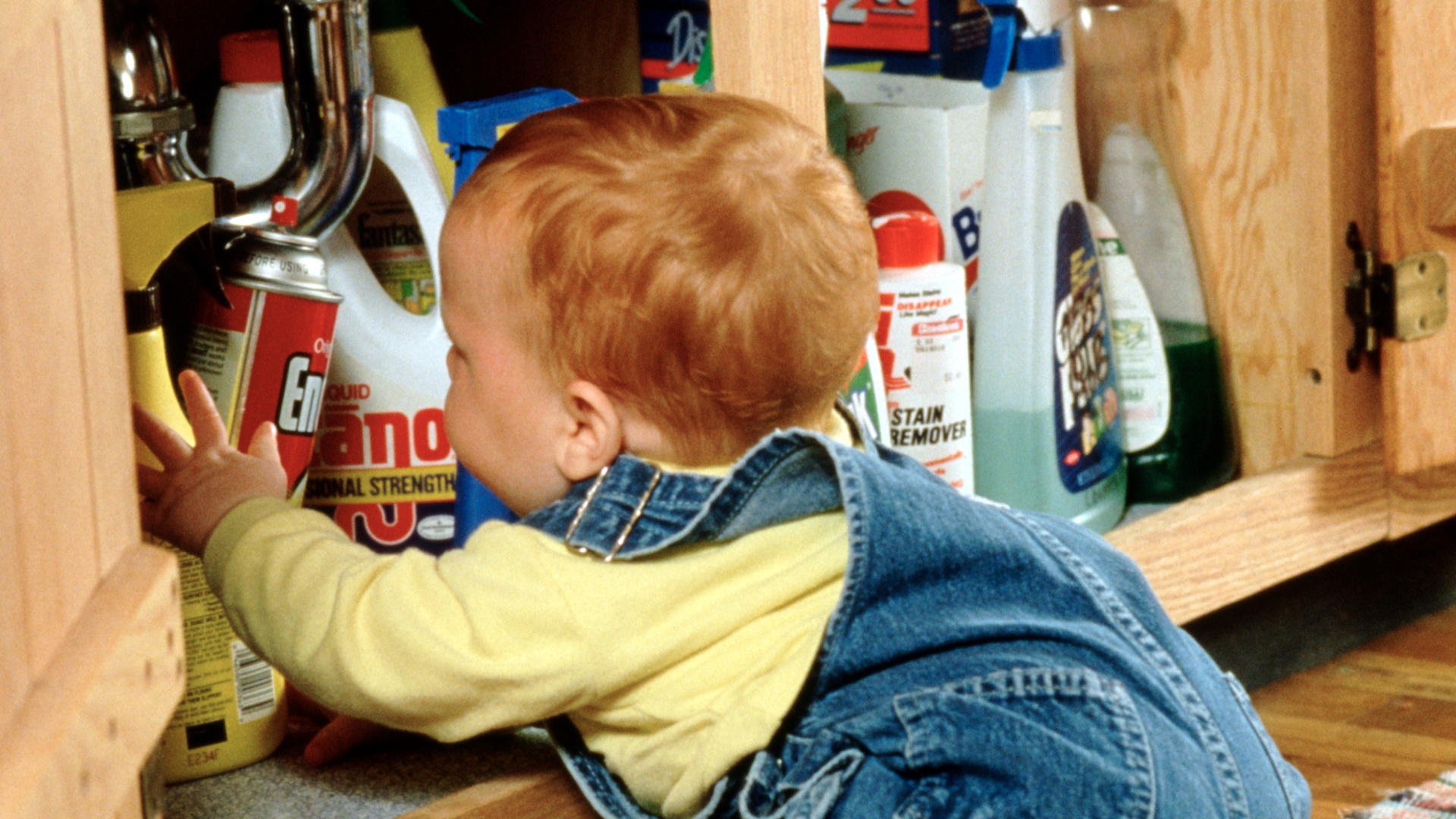 A small child looks through a cupboard of cleaning supplies in this undated file photo. (Getty Images)