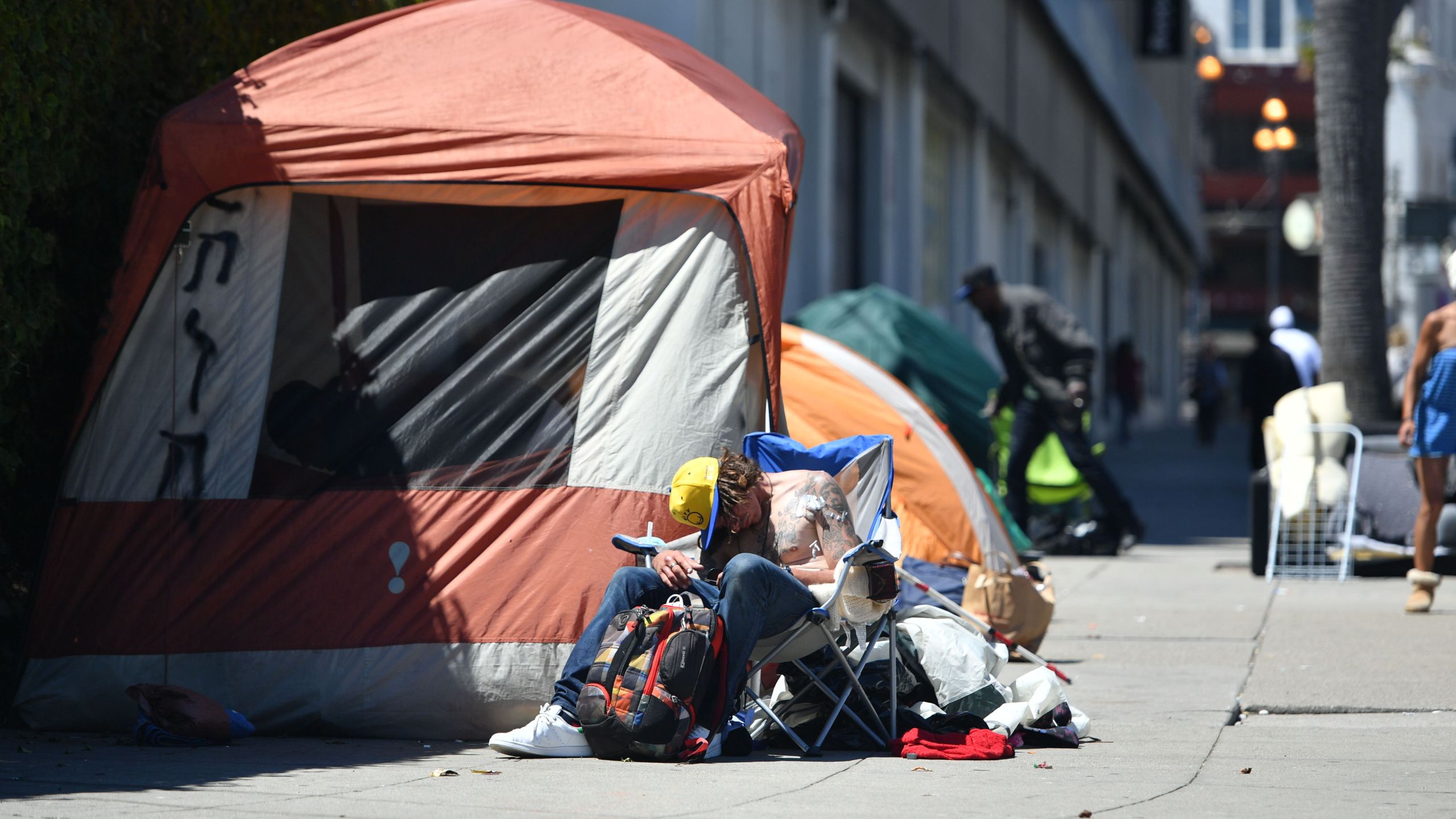 A man sleeps in front of his tent along Van Ness Avenue in downtown San Francisco, California on June, 27, 2016. (Josh Edelson/AFP via Getty Images)