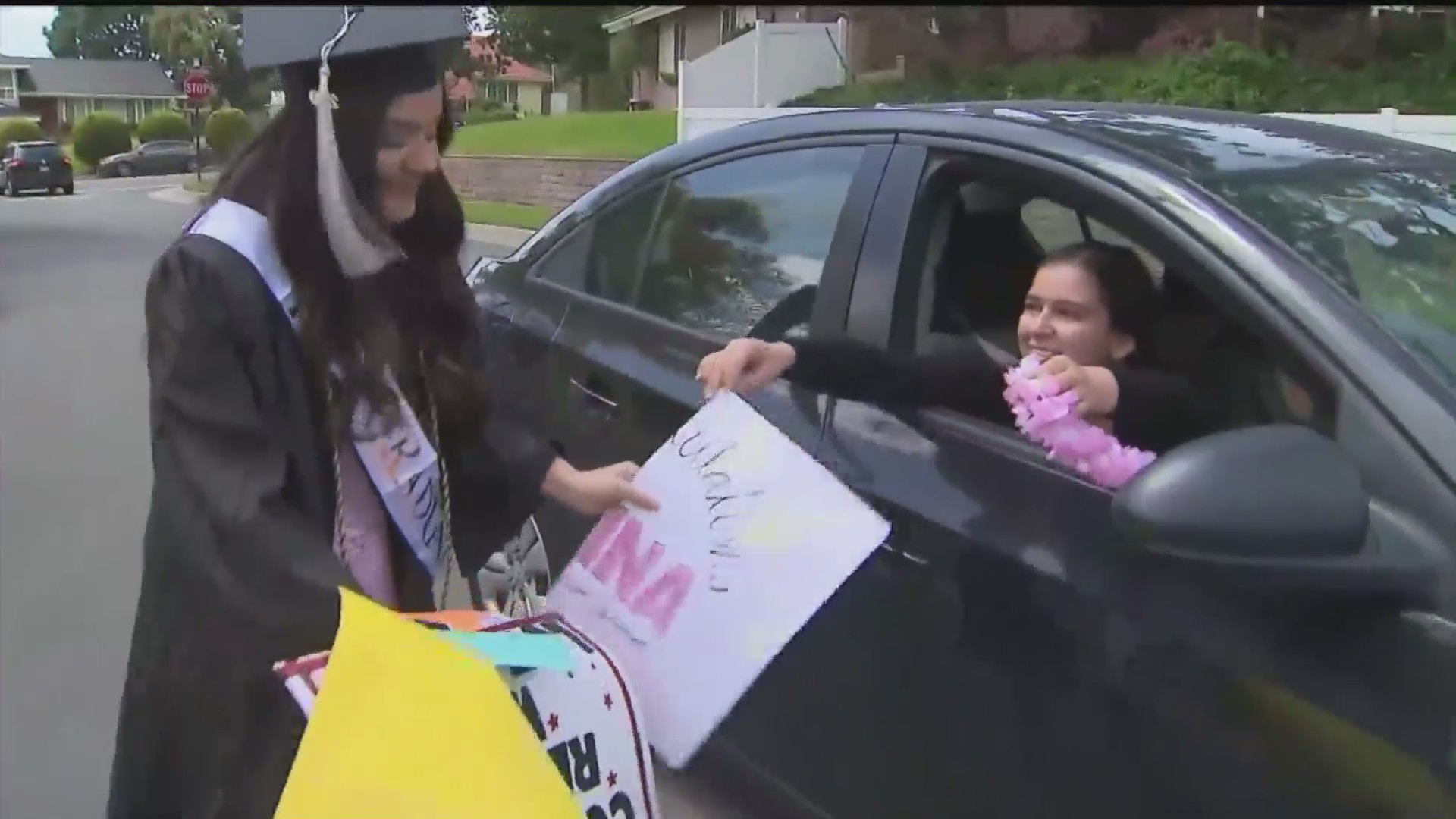 Regina Turiace is surprised with a graduation party caravan outside her home in San Dimas to mark her graduation from the University of Redlands. (KTLA)