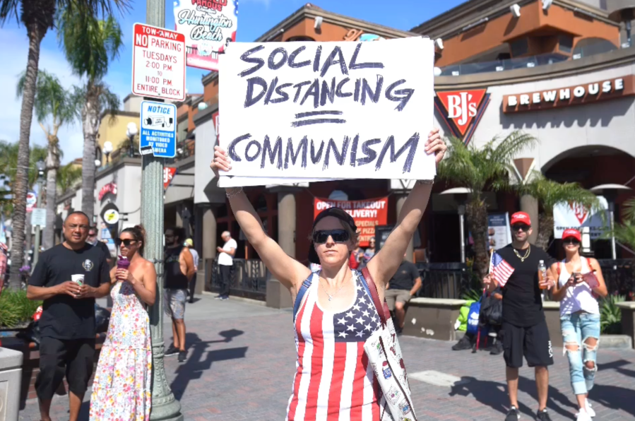 A demonstrator in Huntington Beach protests against local and statewide stay-at-home orders amid the coronavirus pandemic on April 17, 2020. (OC Hawk)