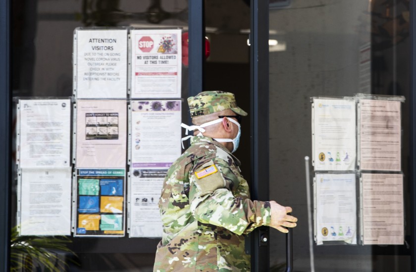 National Guard Sgt. Joseph Schlitz enters the Hollywood Premier Healthcare Center in April 2020. The facility has seen 25 cases among staff and 29 among residents. (Brian van der Brug/Los Angeles Times)