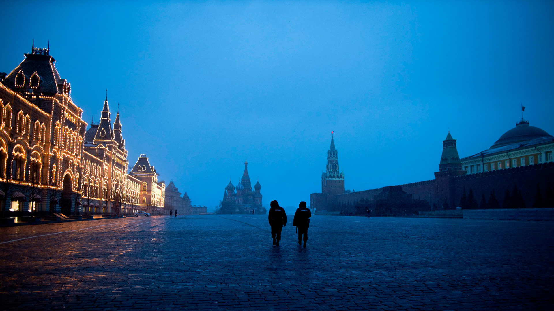 Two police officers patrol an almost empty Red Square, with St. Basil's Cathedral, center, and Spasskaya Tower and the Kremlin Wall, right, at the time when its usually very crowded in Moscow, Russia. (Alexander Zemlianichenko/AP)