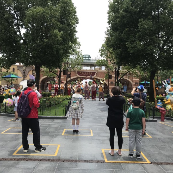 Yellow boxes are taped on the ground to maintain social distancing among visitors inside the park. One family is allowed to stand in each box.(Alice Su / Los Angeles Times)