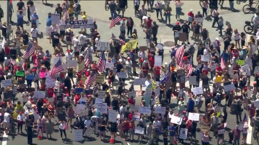 Demonstrators gather in Huntington Beach on May 1, 2020, to protest the state's stay-at-home order. (KTLA)