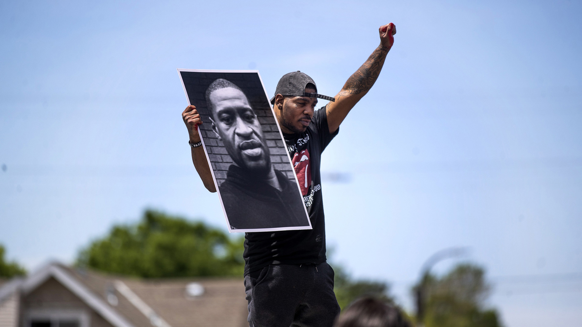 Tony L. Clark holds a photo of George Floyd outside a convenience store, Thursday, May 28, 2020, in Minneapolis. (Credit: Jerry Holt/Star Tribune/AP)