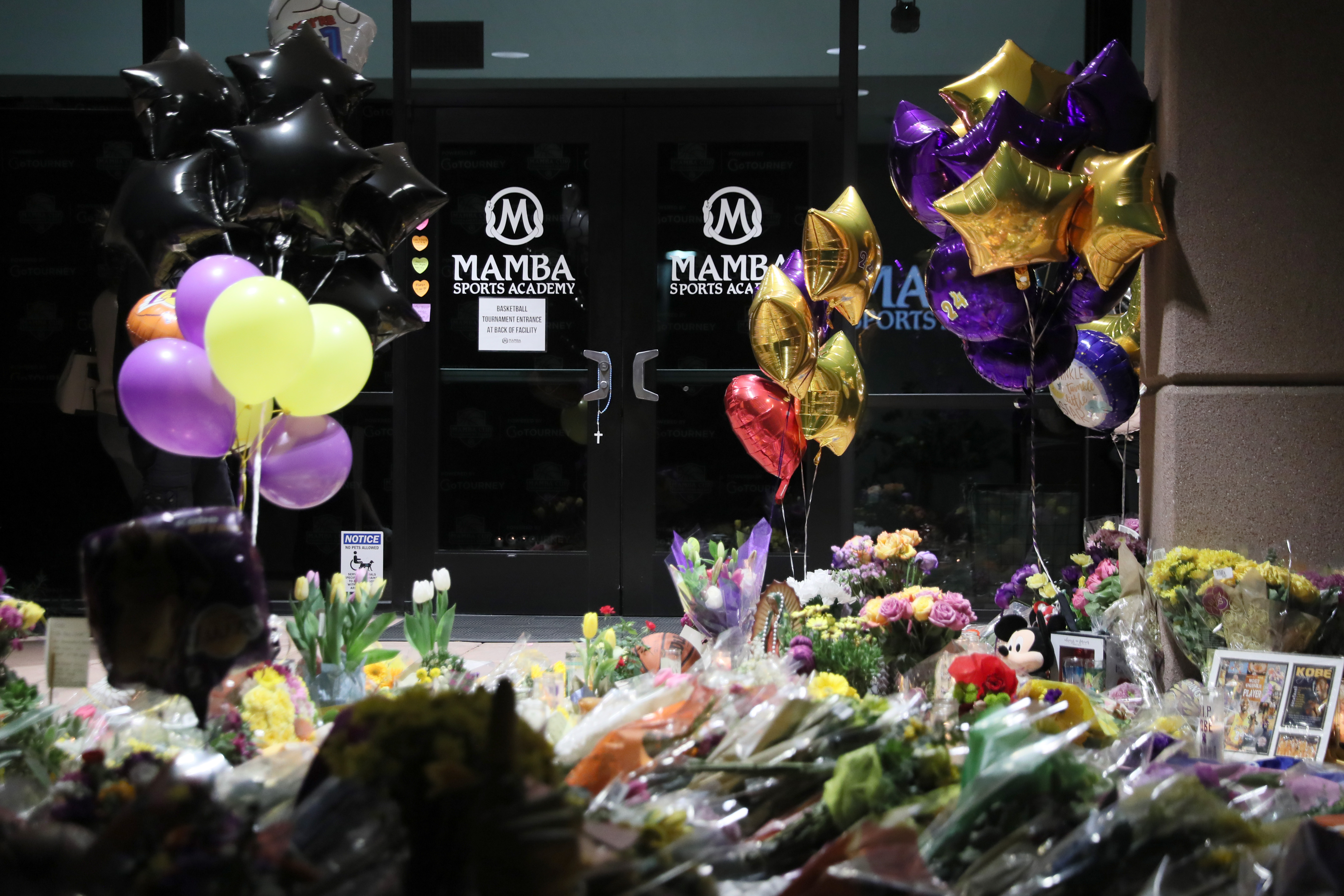 The entrance of Mamba Sports Academy in Newbury Park, Calif., is surrounded by flowers and other gifts in memory of NBA champion and two-time Olympic gold medalist Kobe Bryant, 41, his daughter, Gianna, and seven others, who died in a helicopter crash on Jan. 26, 2020. (Josh Lefkowitz/Getty Images)