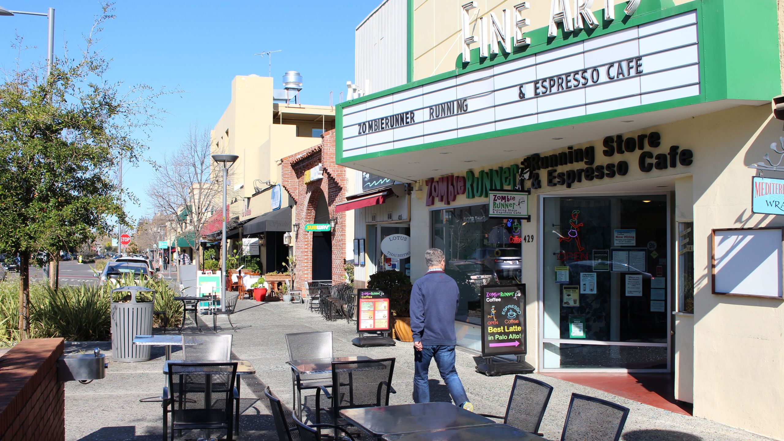 A man glances into ZombieRunner coffee shop as he strides along a quiet sidewalk in downtown Palo Alto, a social hub for tech workers and students at nearby Stanford University who are being advised to "socially distance" to prevent the spread of novel coronavirus on March 12, 2020. (GLENN CHAPMAN/AFP via Getty Images)