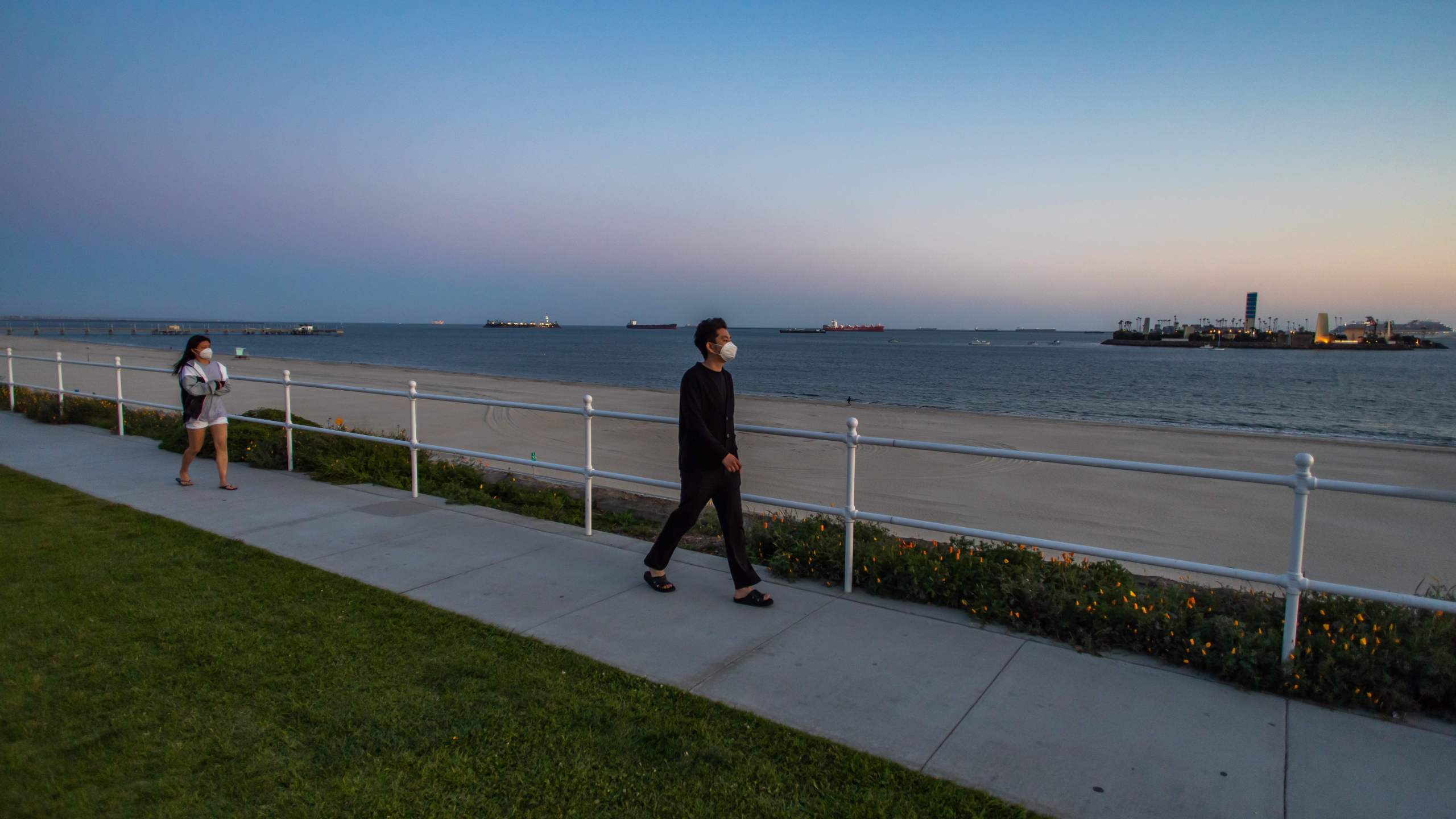 People walk by the sea in Long Beach, California on March 29, 2020. (APU GOMES/AFP via Getty Images)