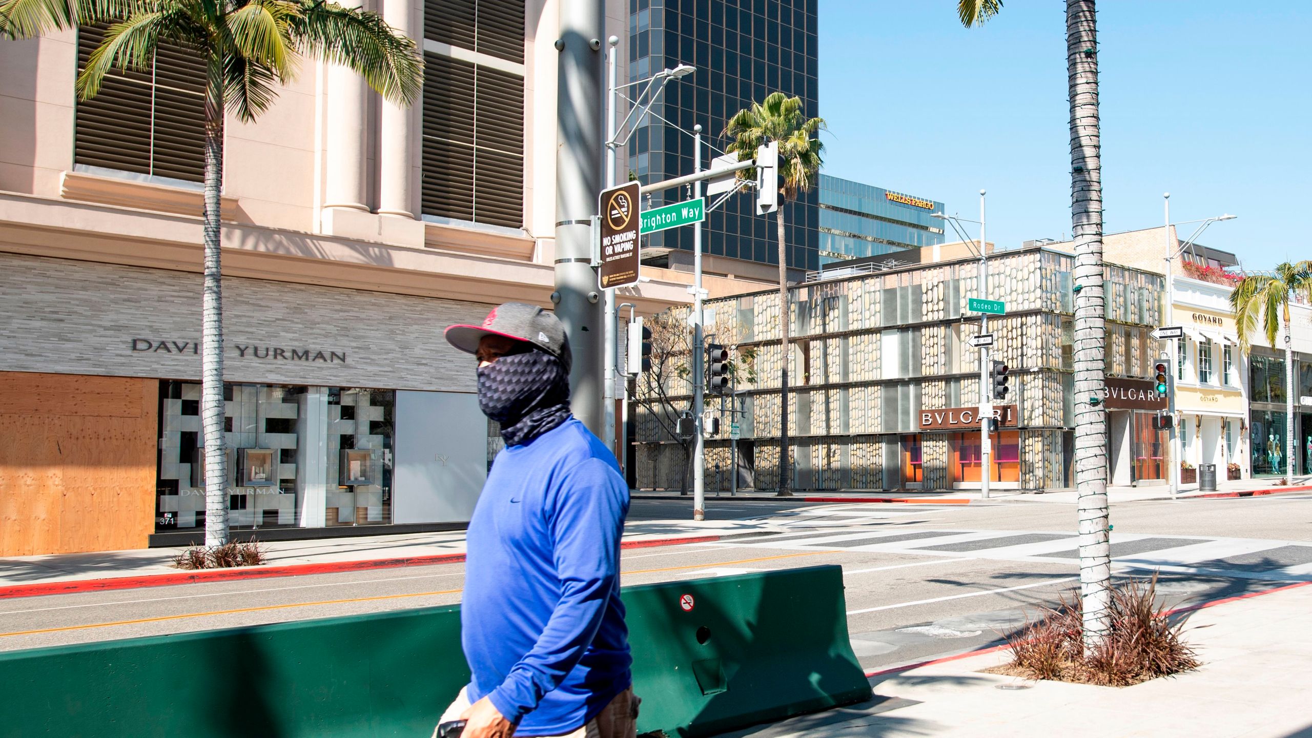 A person wearing a mask walks on Rodeo Drive in Beverly Hills on April 1, 2020, during the Covid 19 crisis. (VALERIE MACON/AFP via Getty Images)