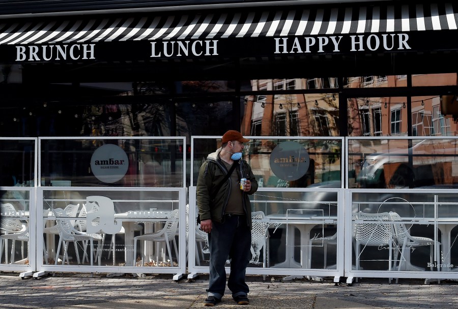 A man wearing a face mask stands outside a closed restaurant as local bussiness try to adapt due to concerns with the spread of the coronavirus on April 2, 2020 in Arlington, Virg. (OLIVIER DOULIERY/AFP via Getty Images)