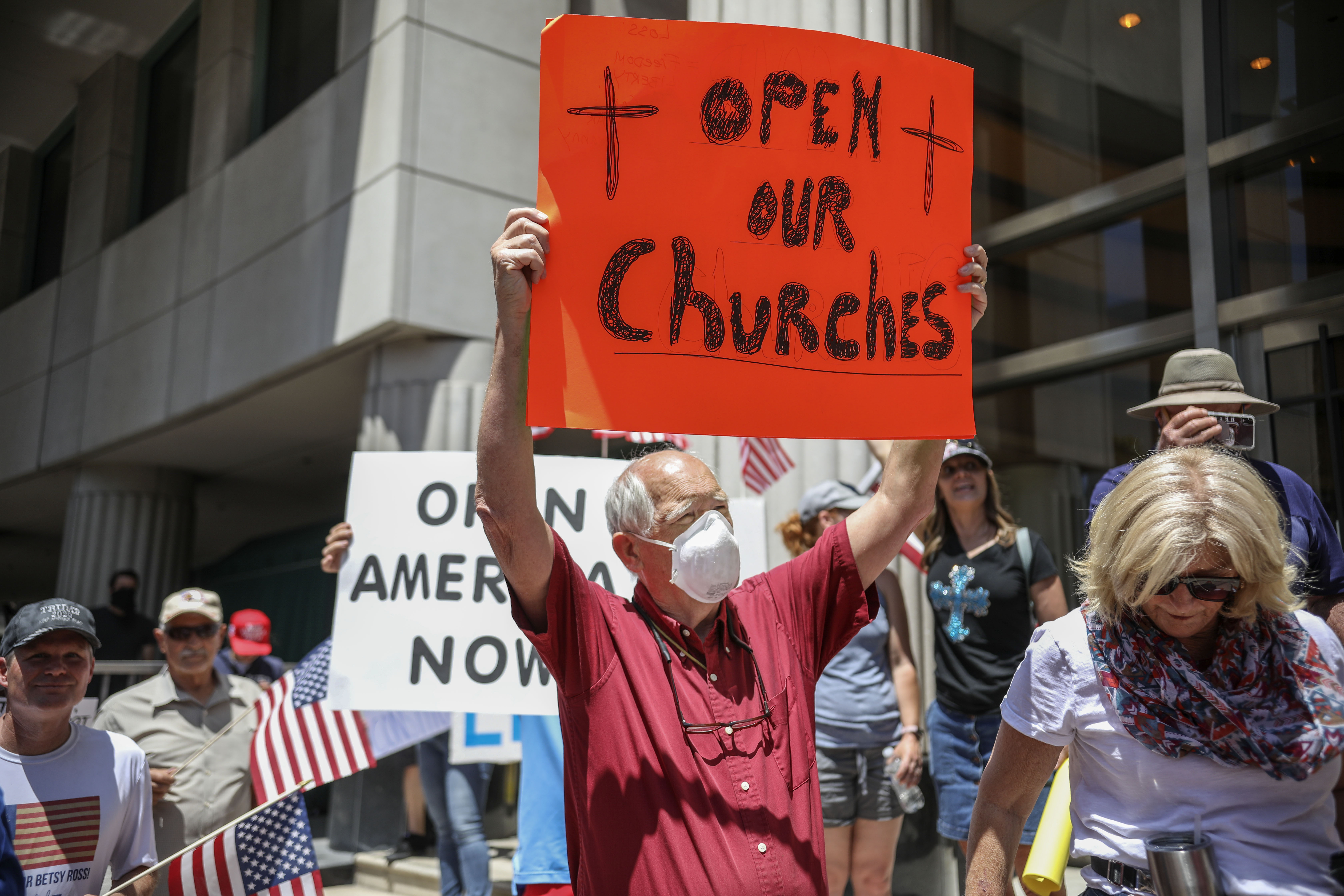 Demonstrators, holding signs demanding their church reopen, protest during a rally to reopen California and go against Stay-At-Home directives on May 1, 2020 in San Diego. Rallies have been held at several state capitols across the country as protesters express their deep frustration with the stay-at-home orders that are meant to stem the spread of the novel coronavirus. (Sandy Huffaker / AFP via Getty Images)